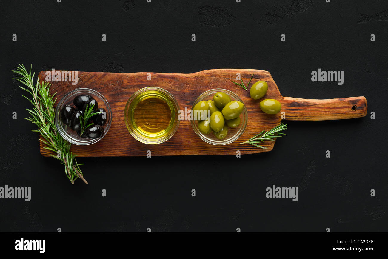 Olivenöl und Oliven in Schalen an Bord. Stockfoto