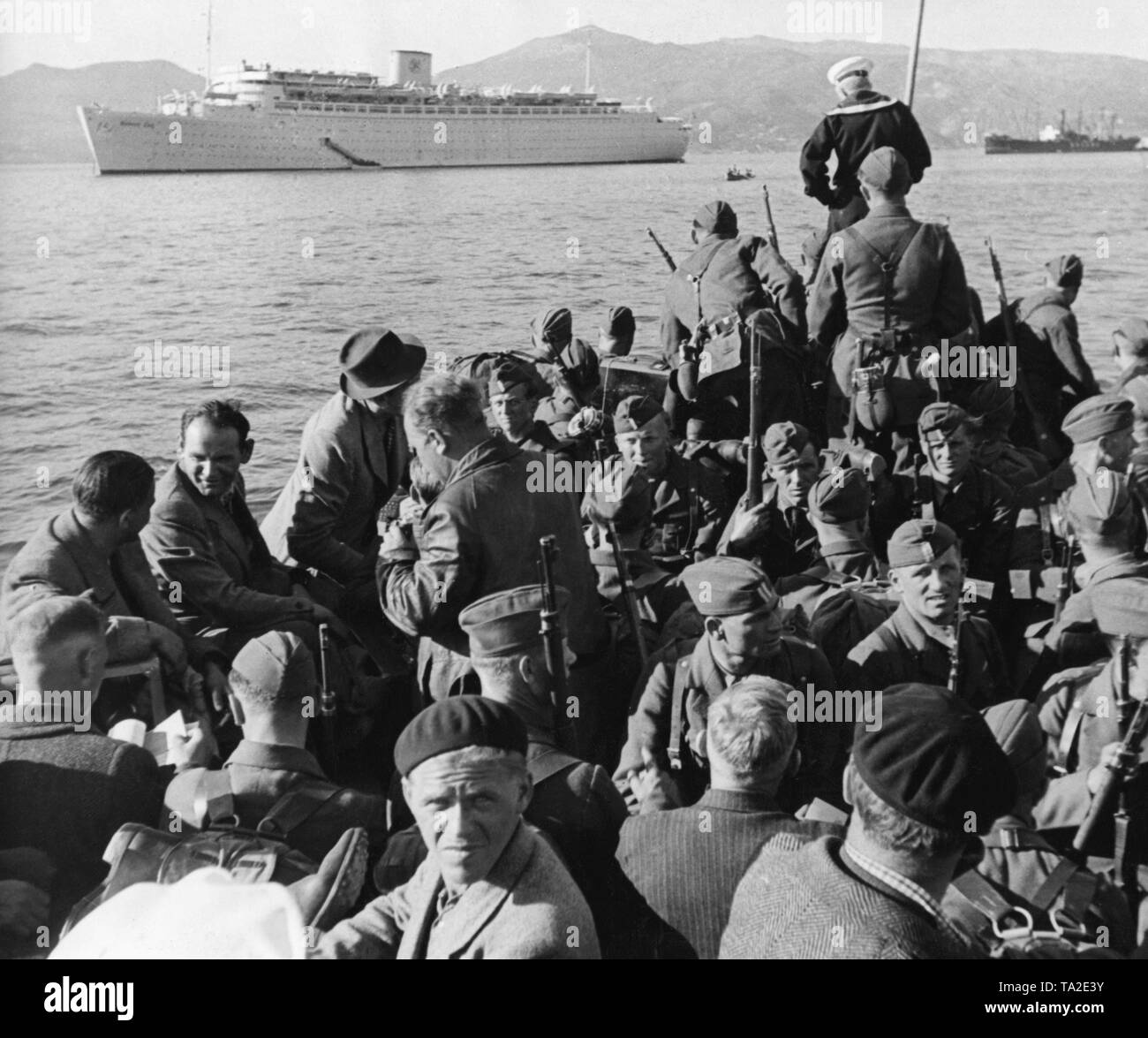 Foto von deutschen Soldaten (in Zivil oder in Uniform) der Legion Condor während der Rückfahrt in den Hafen von Vigo, Galicia am 30. Mai 1939. Im Hintergrund die 'Kraft durch Freude' ('Stärke durch Freude" (KdF) Dampfgarer Flotte), "Robert Ley", der eigentlich die militanten Home, der in Spanien gekämpft haben, zu bringen. Stockfoto