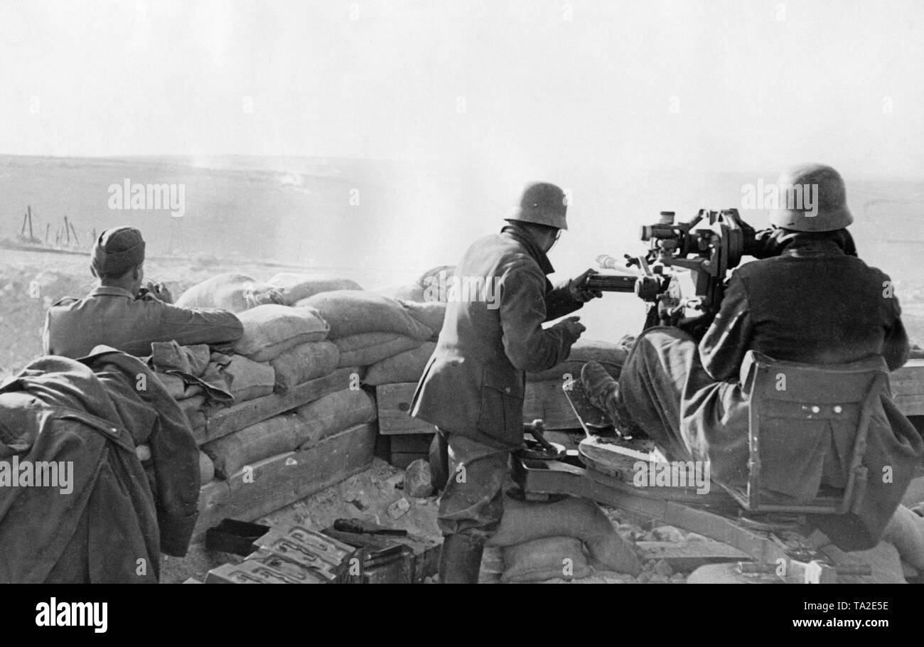 Undatiertes Foto einer zielüberwachung Einheit der Legion Condor während einer Bereitstellung im Spanischen Bürgerkrieg. Zwei Männer sind, die auf dem Boden mit einer 2-cm-FLAK 39 Ziel in einem sandsack Stellung. Ein Offizier (links) nimmt die Ziele. Auf der linken Seite im vorderen Bereich gibt es Kisten Munition. Die Soldaten tragen M 35 Stahlhelme. Stockfoto