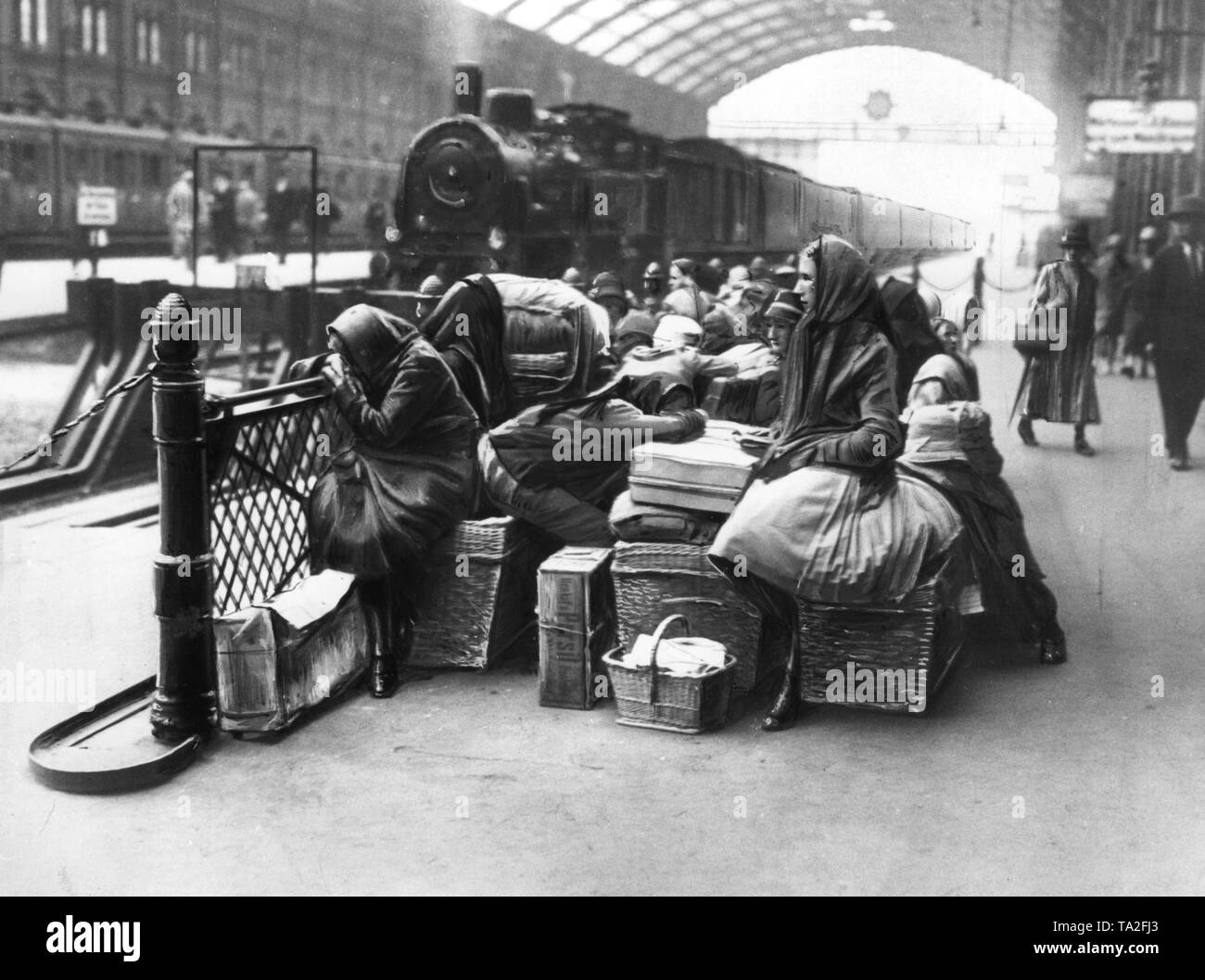 Die Mitglieder einer Familie sitzen auf Ihren gepackten Taschen und Gepäck beim warten auf Ihren Zug vermutlich am Hauptbahnhof in Berlin. Stockfoto