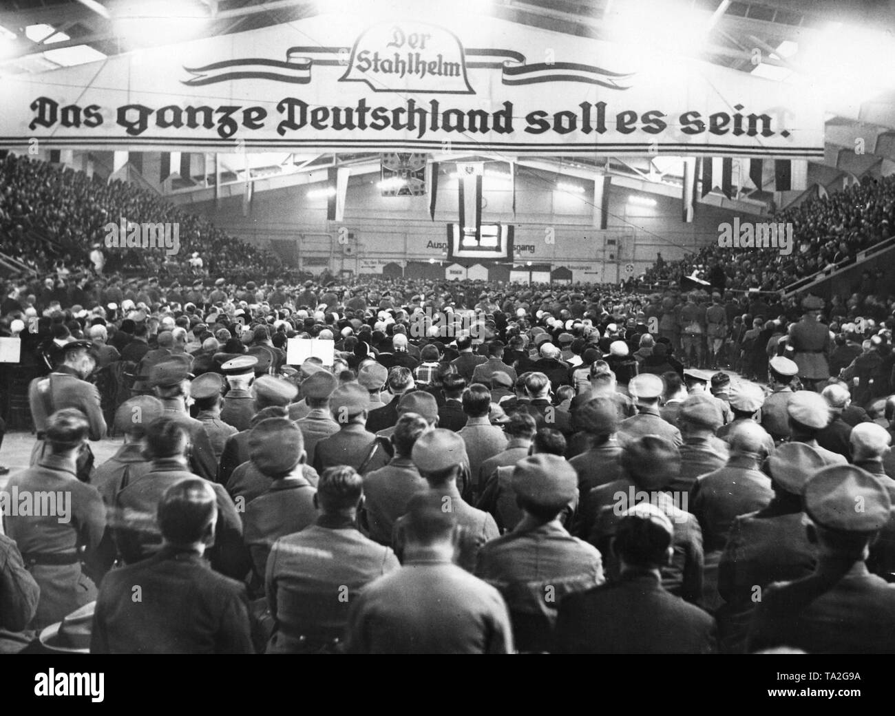 Ansicht der Hall während einer Rede von Bundesfuehrer (Gouverneur) Franz Seldte (rechts), auf einem Reich Grundsteinlegung organisiert von Gau 3 Der Stahlhelm in der Tennishalle in Berlin-Wilmersdorf. Unter dem Logo der Stahlhelm, gibt es die Inschrift: "Es sollen alle Deutschland sein", ein Zitat aus dem Song "Deutschen Vaterland" von Ernst Moritz Arndt. Stockfoto