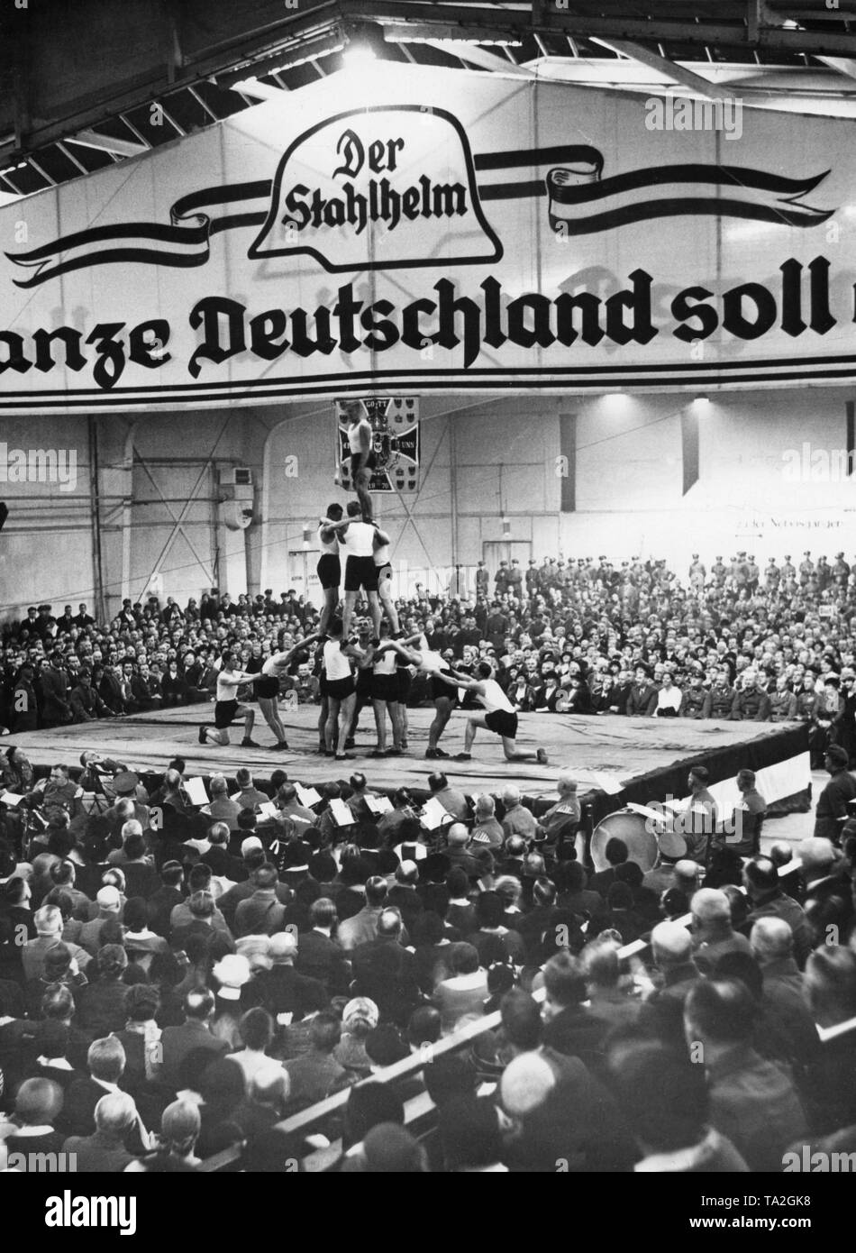 Foto von Gymnastik Aufführungen der Jungstahlhelm (junge stahlhelm) an der Reichsgruendungsfeier der Gau 3 Der Stahlhelm in der Tennishalle (Gericht) in Berlin-Wilmersdorf. Unter dem Logo der Stahlhelm, gibt es die Inschrift: "Es sollen alle Deutschland" sein. Stockfoto