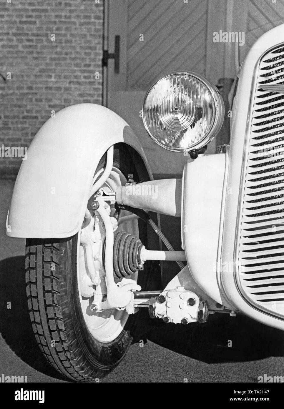 Die vordere Federung von Frontantriebsachse Adler Trumpf Junior mit Einzelradaufhängung, Antriebswelle und der Bremstrommel. Stockfoto