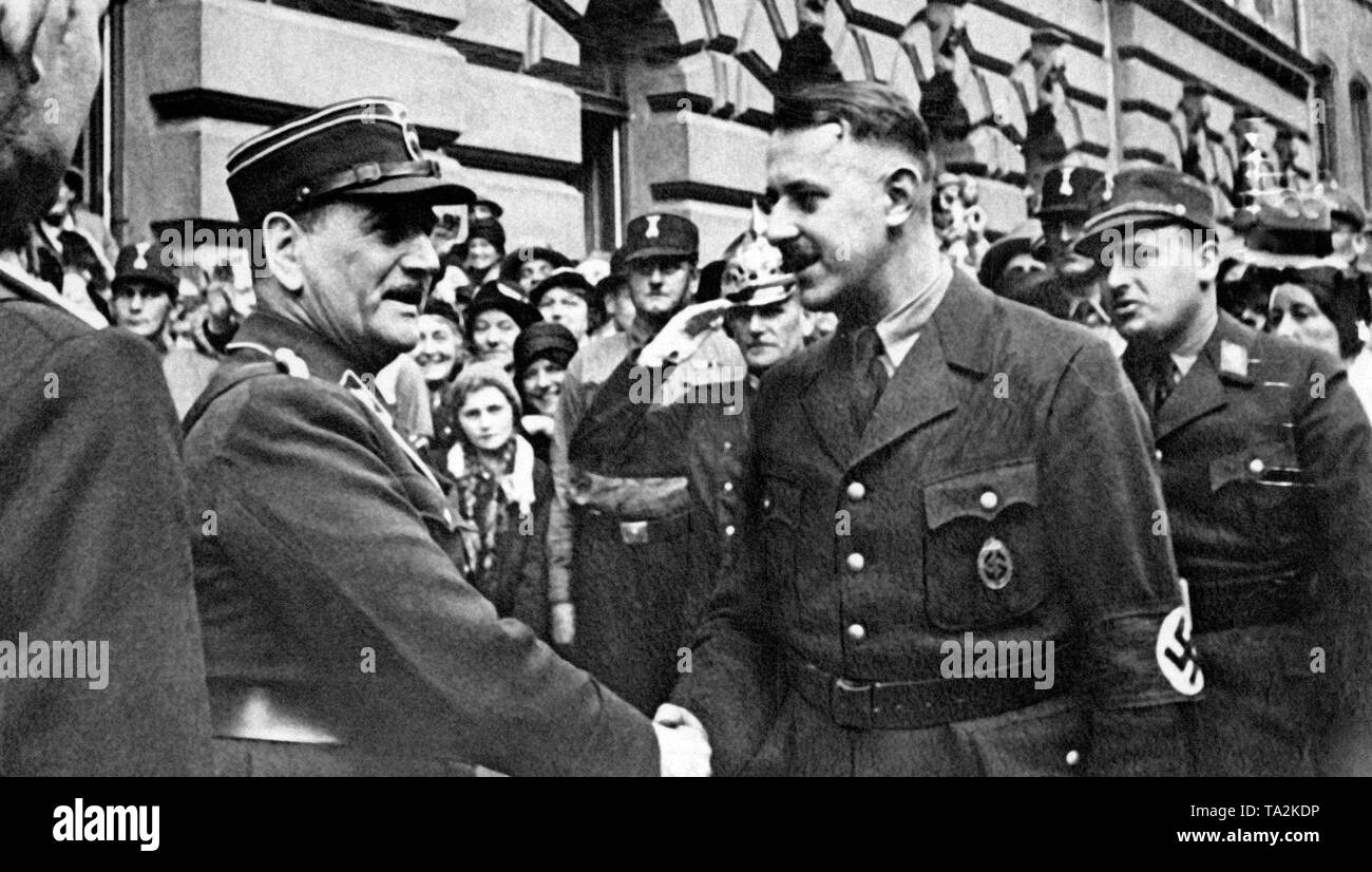 Diese Aufnahme zeigt den neuen nationalsozialistischen Staatsminister Hermann Winkler (rechts), beglückwünscht die Reich Gouverneur Ritter von Epp, der durch die Berliner Reichsregierung ernannt wurde, in die NSDAP in Bayern. Im Hintergrund das alte Parlament Gebäude. Esser trägt den Coburg Abzeichen, bestehend aus Hakenkreuz und Schwert das Schwert steht für die SA. Die coburger Abzeichen wird nach dem 3. Deutschen Tag in Coburg, zu der Hitler war mit mehreren SA Männer für eine Rally genannt, und während der Veranstaltung mehrere Straßenkämpfe aufgetreten mit den Anhängern der Partei Die Linke. Neben der Partei- und SA-Männer, die Stockfoto