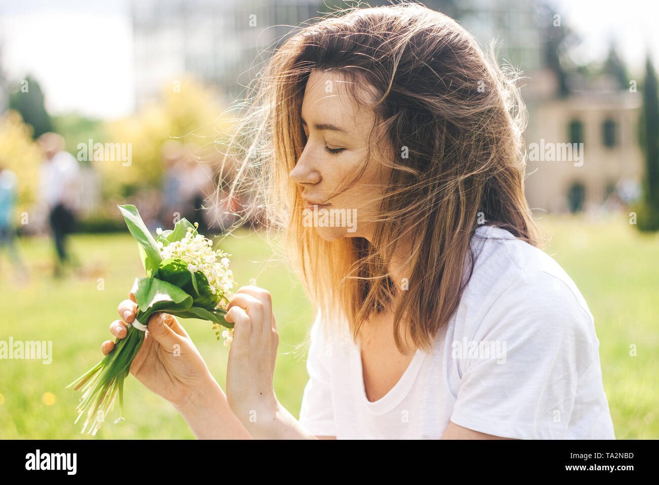 Frau mit schönen Blumenstrauß von Lilly von Tal der Blumen im sonnigen warmen Tag Stockfoto