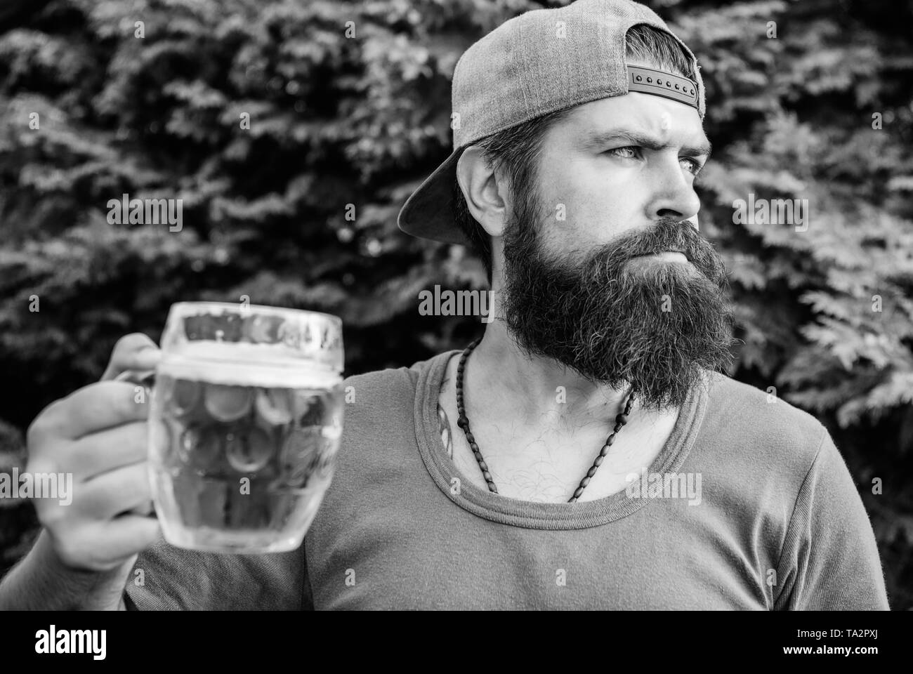 In der Pause. Mann Trinker holding Bierkrug im Freien. Brutale Hipster in Handwerk Bier am Tag. Bärtiger Mann genießen Sie Bier trinken auf die Natur. Bier mich. Stockfoto