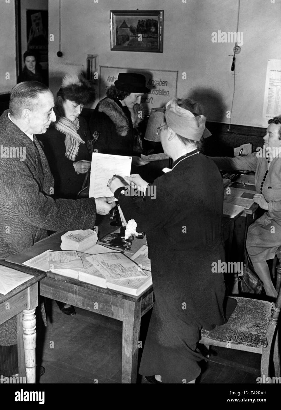 Ausgabe der Anmeldeformulare für den Arbeitseinsatz (Bereitstellung) von Männern und Frauen in einem Büro in Berlin West als Teil von Goebbels' Total War' Programm. Foto: Schwahn Stockfoto