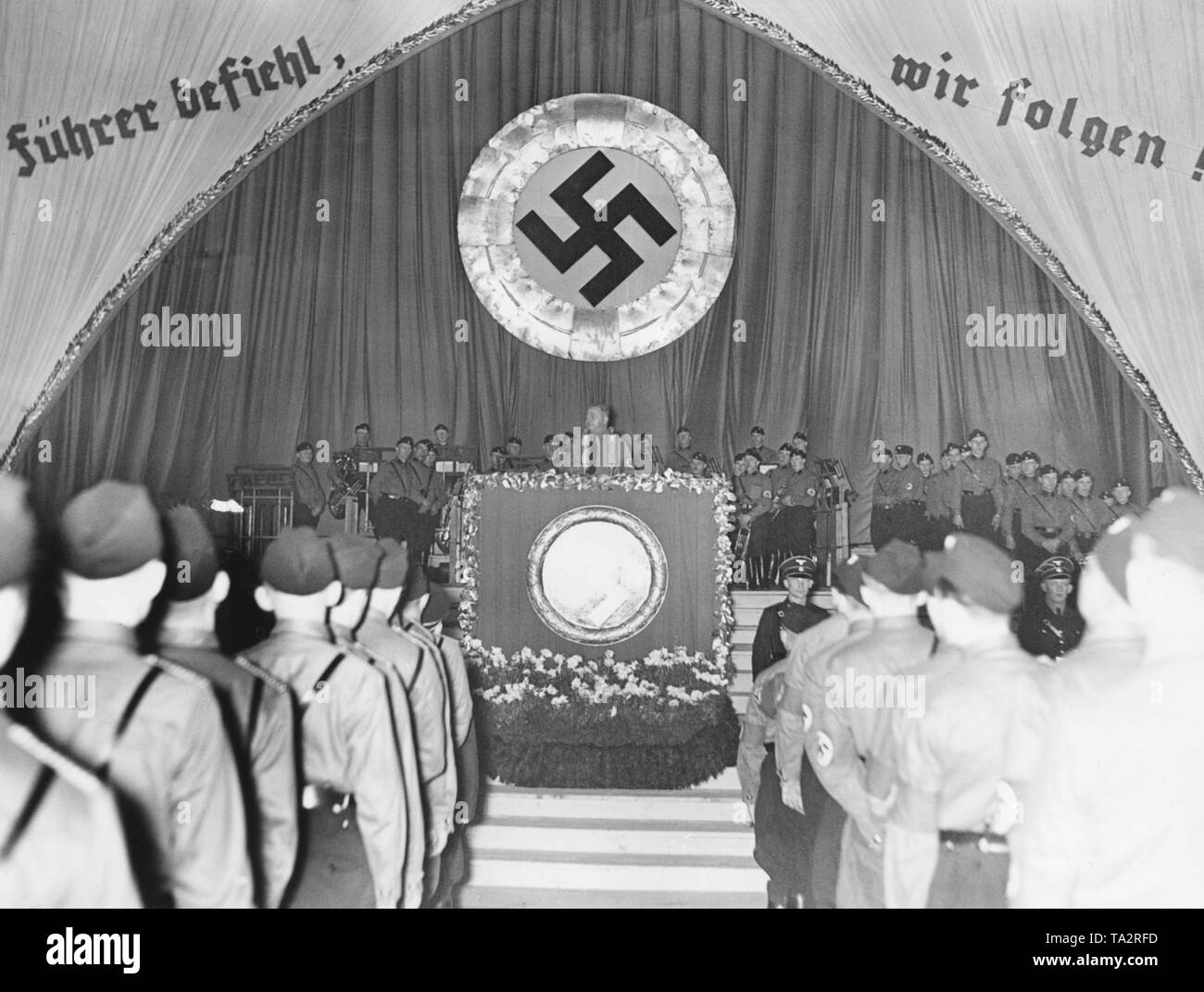 Wahl Rallye in der Saengerhalle in Cheb. Gauleiter Josef Brueckel gibt eine Rede. Die Sudetendeutschen halten eine Neuwahl über die Annexion des Sudetenlandes an das Deutsche Reich. Im Hintergrund: "Der Führer Bestellungen, und wir folgen!'. Stockfoto