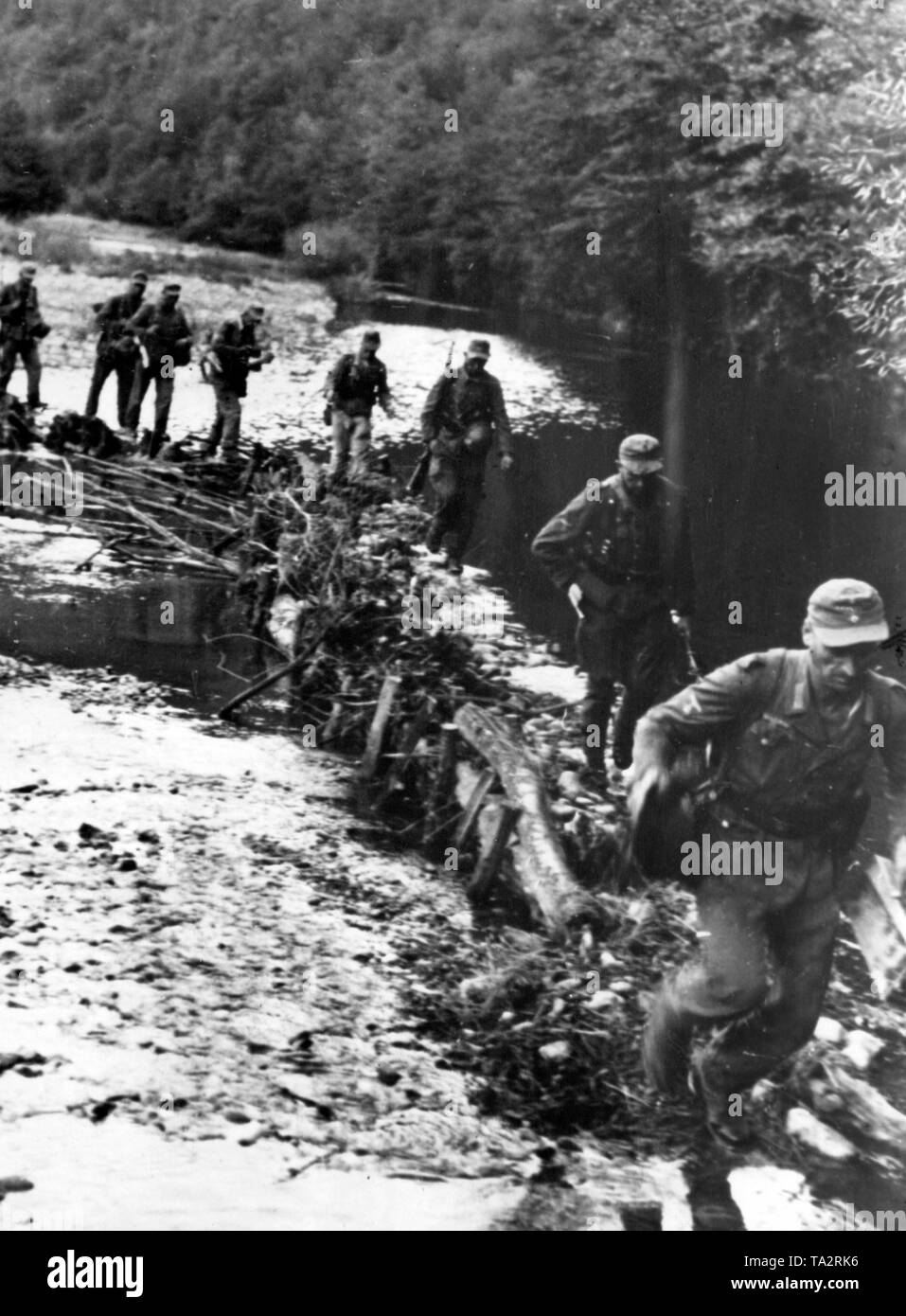 Deutsche Soldaten cross a mountain river in den westlichen Karpaten mit Hilfe einer improvisierten provisorische Brücke. Foto der Propaganda Firma (PK): Kriegsberichterstatter Kallmerten. Stockfoto