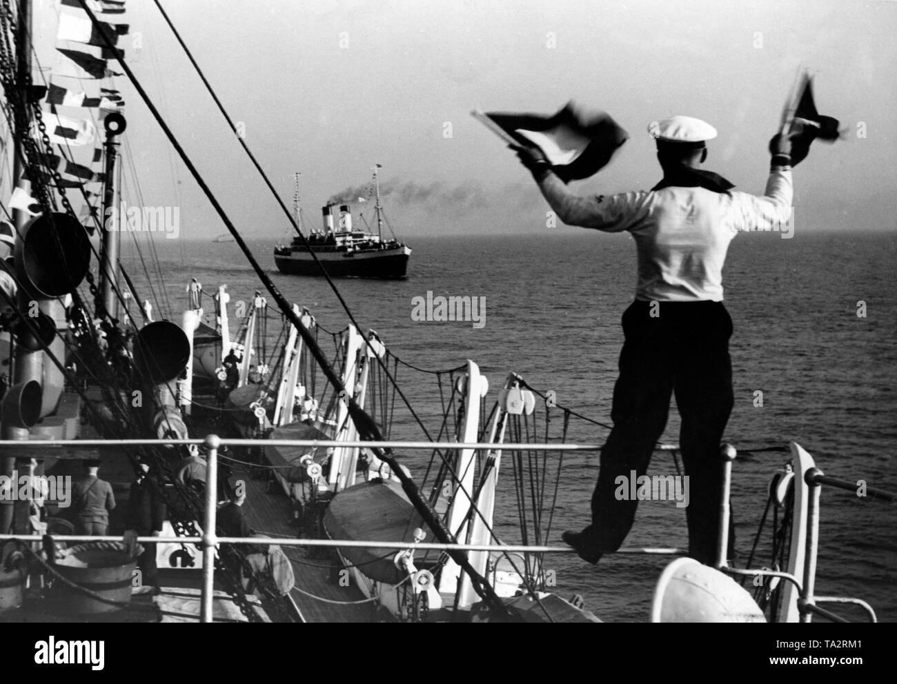 Nachrichten werden durch flag Signale zwischen der Kreuzfahrtschiffe 'Dresden' und 'Monte Olivia" (im Hintergrund) Der NS-Organisation "Kraft durch Freude", der in der Nordsee ausgetauscht. Stockfoto