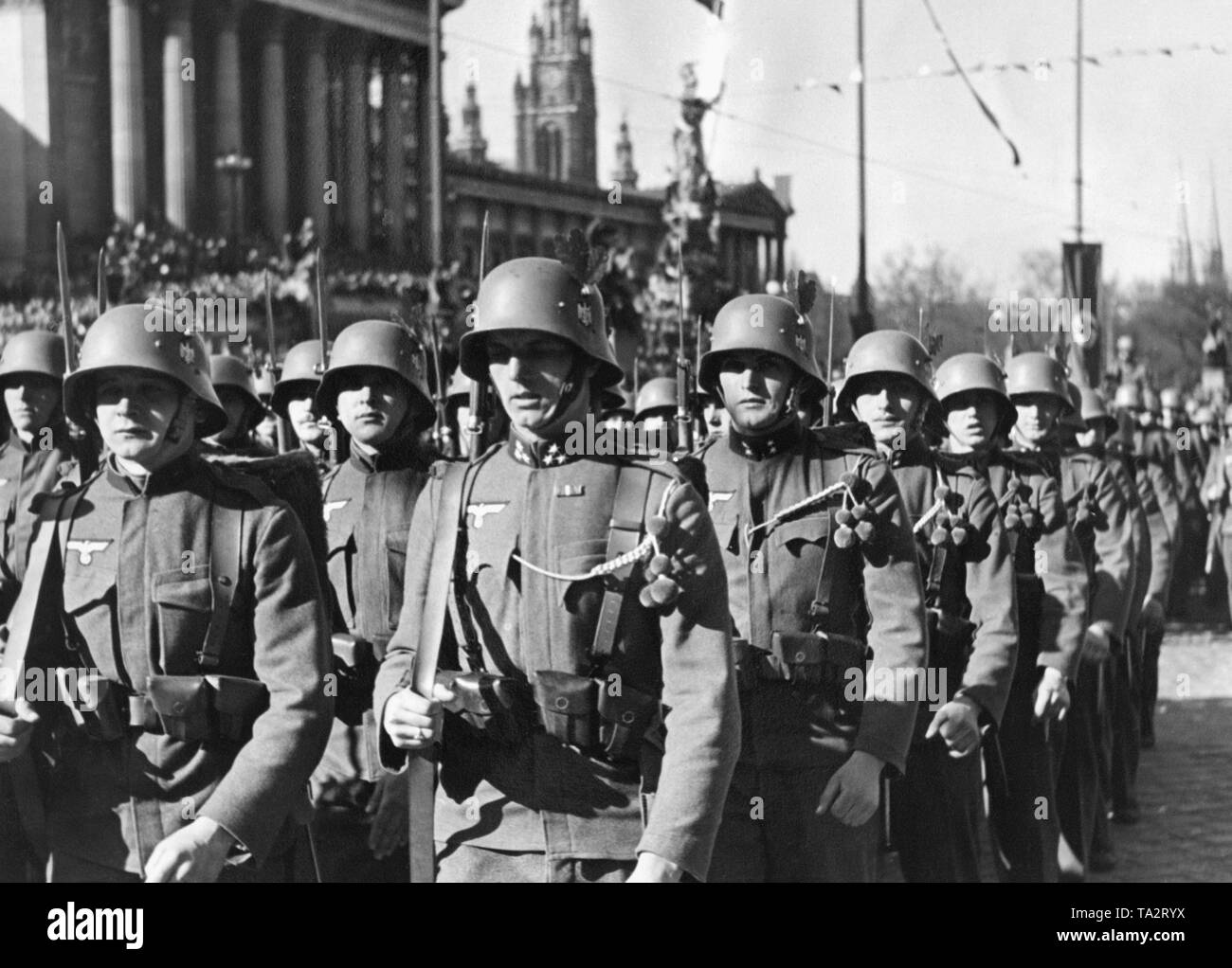 Österreichische Soldaten paradieren vor Adolf Hitler vor dem Parlamentsgebäude in Wien. Die Soldaten tragen den Deutschen Reichsadler mit Hakenkreuz. Feierlichkeiten finden in Wien im Zuge der "Anschluss" Österreichs an das Deutsche Reich. Stockfoto