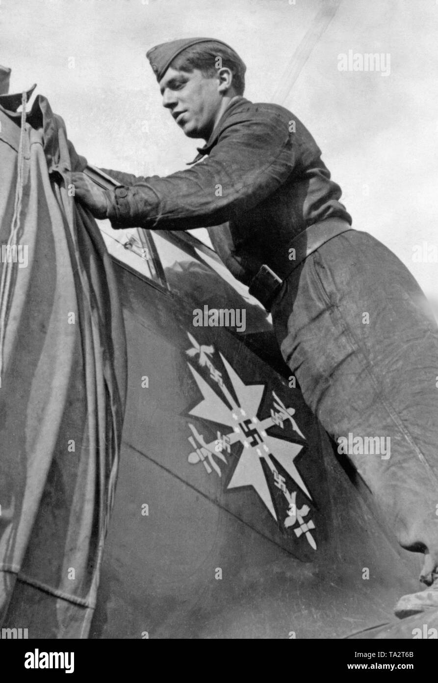 Foto eines deutschen Soldaten des Bodenpersonals, der eine Messerschmitt Bf 109 während der Schlachten von England deckt im Oktober 1940. Auf dem Display der Spanischen Kreuz, das von Adolf Hitler im Spanischen Bürgerkrieg 1939 bis die Kämpfer der Legion Condor ausgezeichnet wurde. Stockfoto