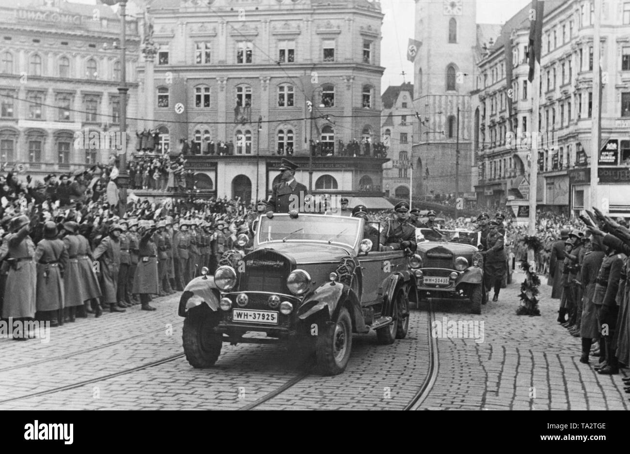 Adolf Hitler der Fahrt durch die Stadt Brünn (heute Brno) im Sudetenland am 17. März 1939 während der Besetzung von den Rest der Tschechischen Gebiet. Hitlers Autokolonne wird von einer jubelnden Bevölkerung. Sie sind Gruß ihn mit den Hitlergruß. Stockfoto