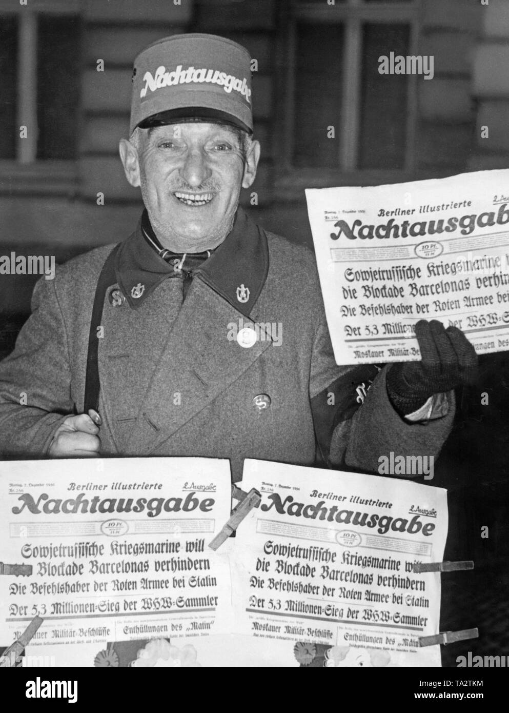 Foto eines newspaperman der "Illustrierte" mit der Late-night-Ausgabe der Zeitung am 7. Dezember 1936 in Berlin. Die Schlagzeile über den Spanischen Bürgerkrieg: "sowjetischen Kriegsmarine (militärische Marine) will die Blockade von Barcelona" zu verhindern. Die republikanische Zeitung hatte die Sowjetunion seit dem Sommer 1936 mit der Lieferung von Waffen und freiwilligen Kämpfer unterstützt. Die nationalistischen Truppen empfing auch internationale Unterstützung. Stockfoto