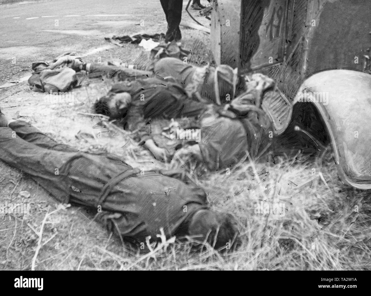 Foto von einer Crew von Artilleriefeuer während der Schlacht von Talavera de la Reina 85 Kilometer von Madrid getötet. Die Toten sind das Tragen der blauen Overall der Republikanischen Milizen. Auf der rechten Seite, ein Teil der Karosserie des Tanks, auf die über Links, die Straße geteert. Stockfoto