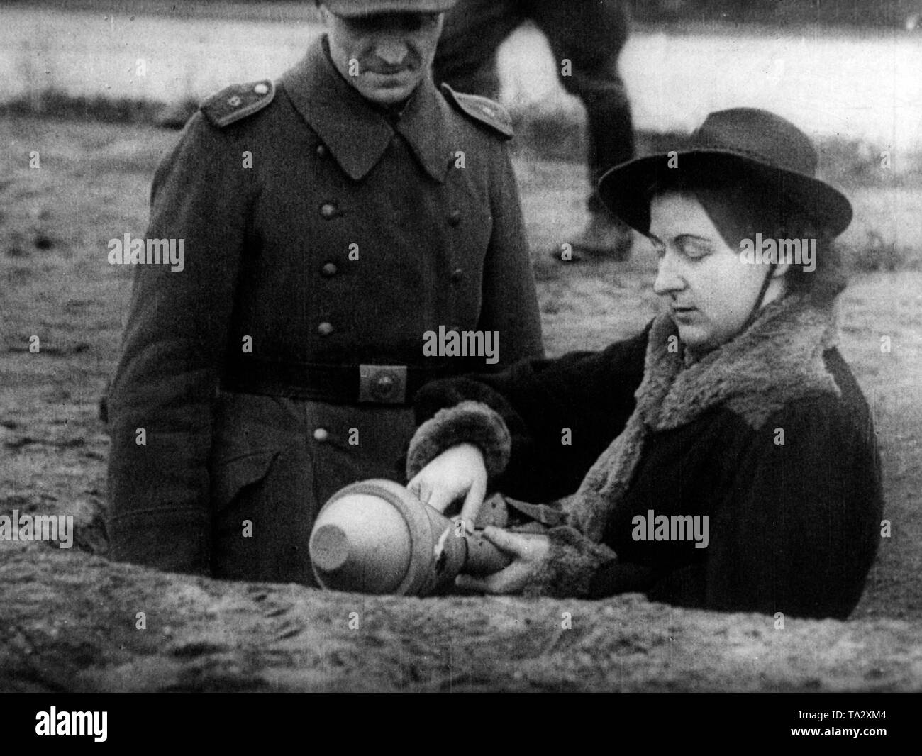 Mitglied der Deutschen Volkssturm erklärt eine Frau, die Handhabung des Panzfaust. Stockfoto