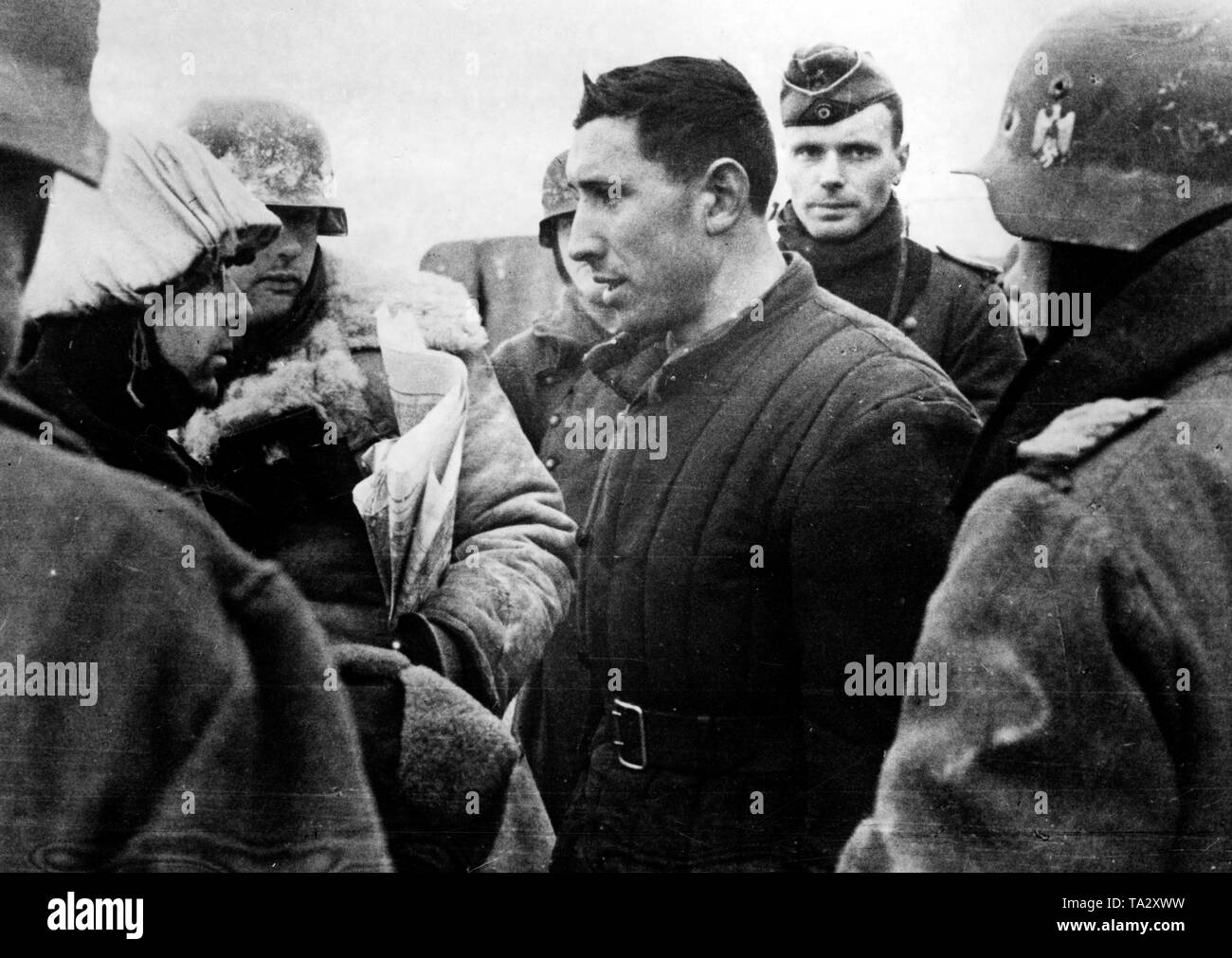 Ein sowjetischer Offizier, der während der Kämpfe an der Moskauer gefangen genommen worden war, ist von einem deutschen Offizier der Wehrmacht verhört. Andere Soldaten stehen um ihn herum. (PK Foto: Krieg Reporter Tepper). Stockfoto