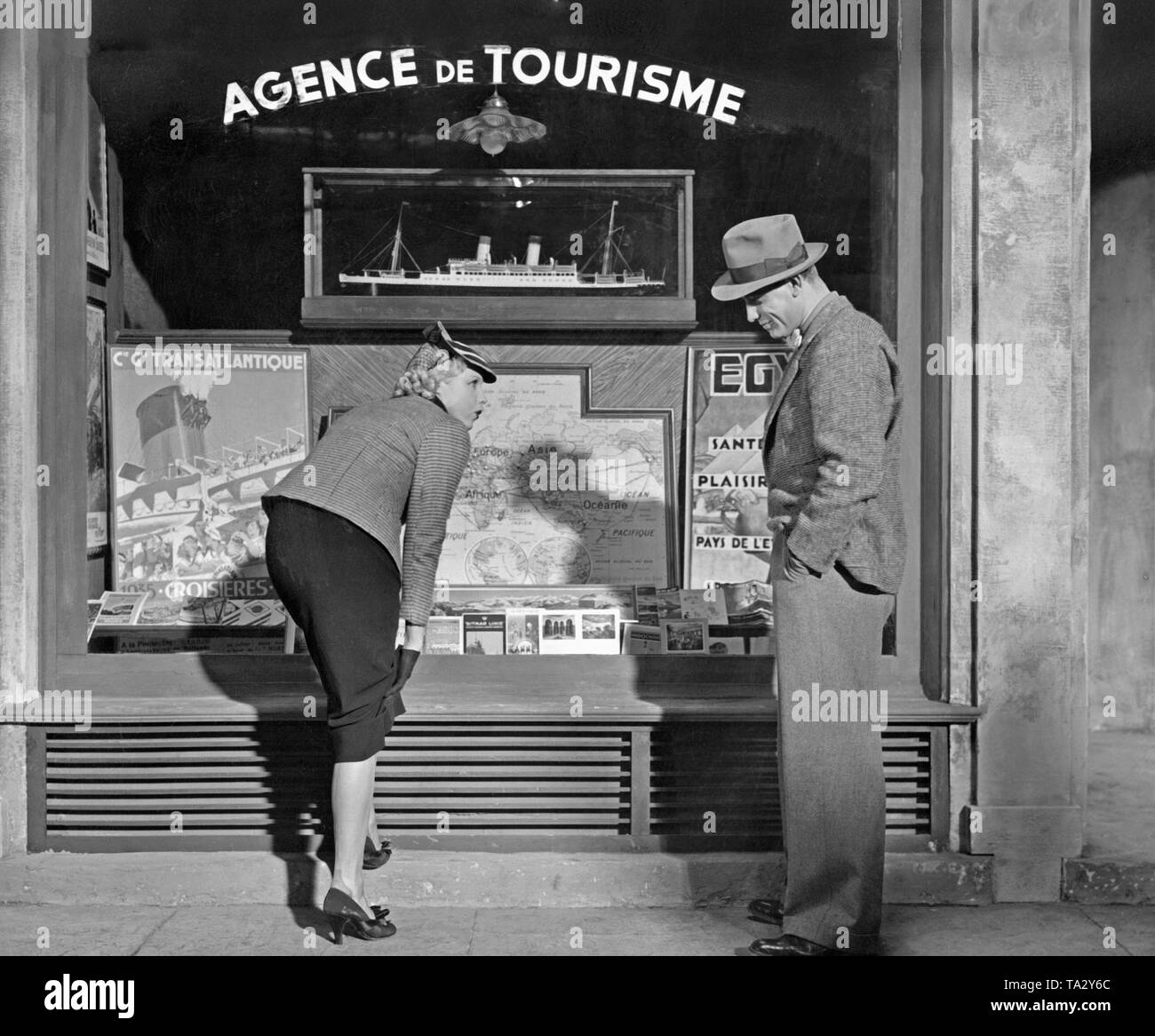 In einem Film der deutsche Film 'Donogoo Tonka", Pierre Lamendin (von Viktor Staal gespielt) und Josette (von Anny Ondra gespielt) stehen vor dem Schaufenster des "Agence de Tourisme', weil der einen Lauf in ihre Strümpfe. Stockfoto