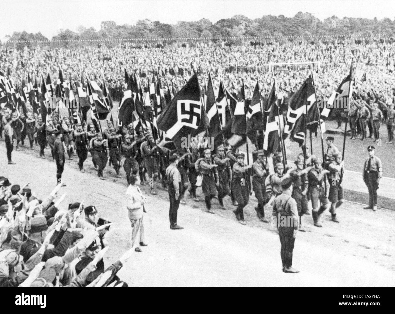 Mitglieder der Hitlerjugend März mit ihren Fahnen vor einer großen Zuschauermenge und andere HJ-Mitglieder auf dem Reichsjugendtag (Reich Tag der Jugend) in Potsdam im Jahr 1932. Stockfoto