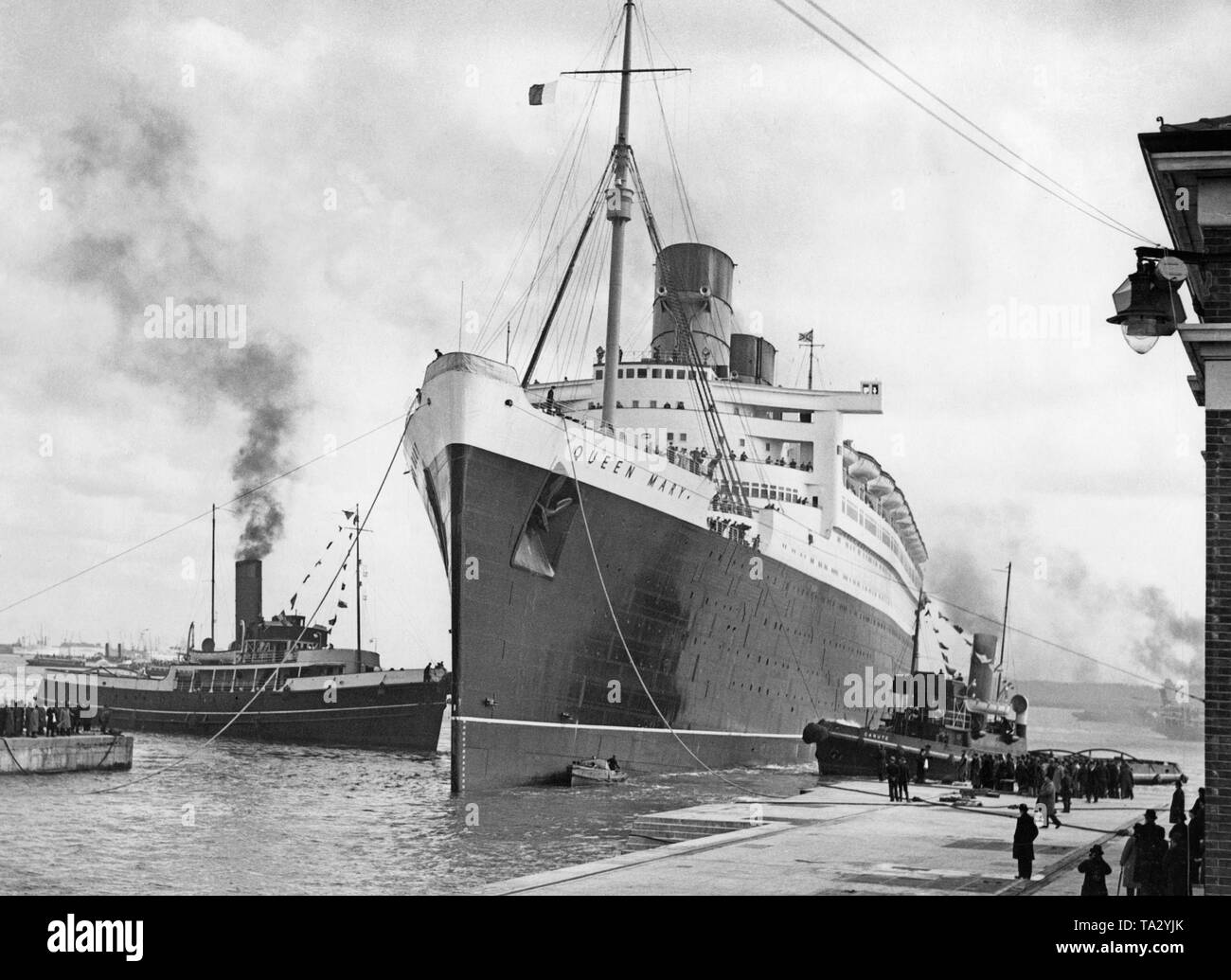 Der cunard Ocean Liner Queen Mary'' von der Werft in Schottland zu Southampton für Rumpf Reinigung in der "King George V Graving Dock' abgeschleppt wird nach ihrer ersten Reise. Stockfoto