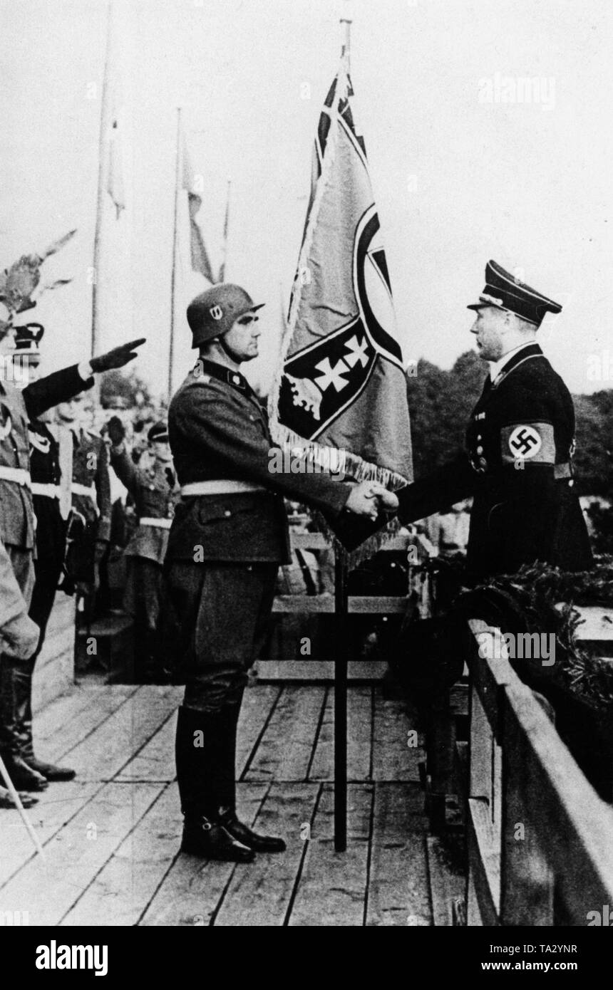 Ns-Gauleiter Albert Forster übergibt eine neue Truppe Banner zum SS-Obersturmbannfuehrer Hans-Friedemann Goetze der SS-Heimwehr Danzig, die unter anderem von den Teilen der SS-Wachsturmbann Eimann entstanden. Stockfoto