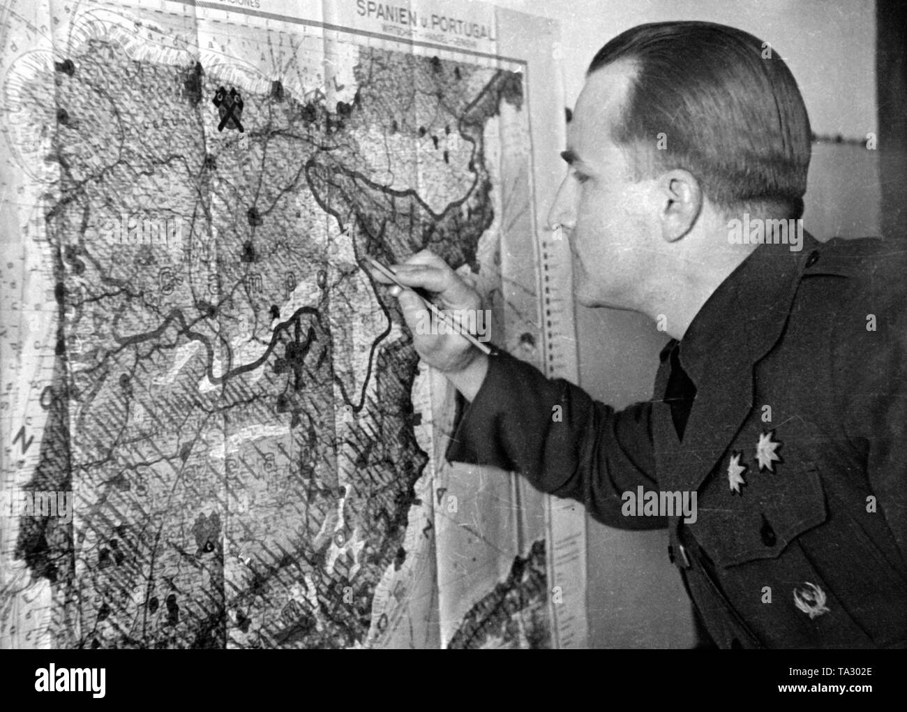 Undatiertes Foto eines Deutschen Major der Legion Condor, während die Korrektur der neuen Linie von der Front in eine Karte der Iberischen Halbinsel. Stockfoto