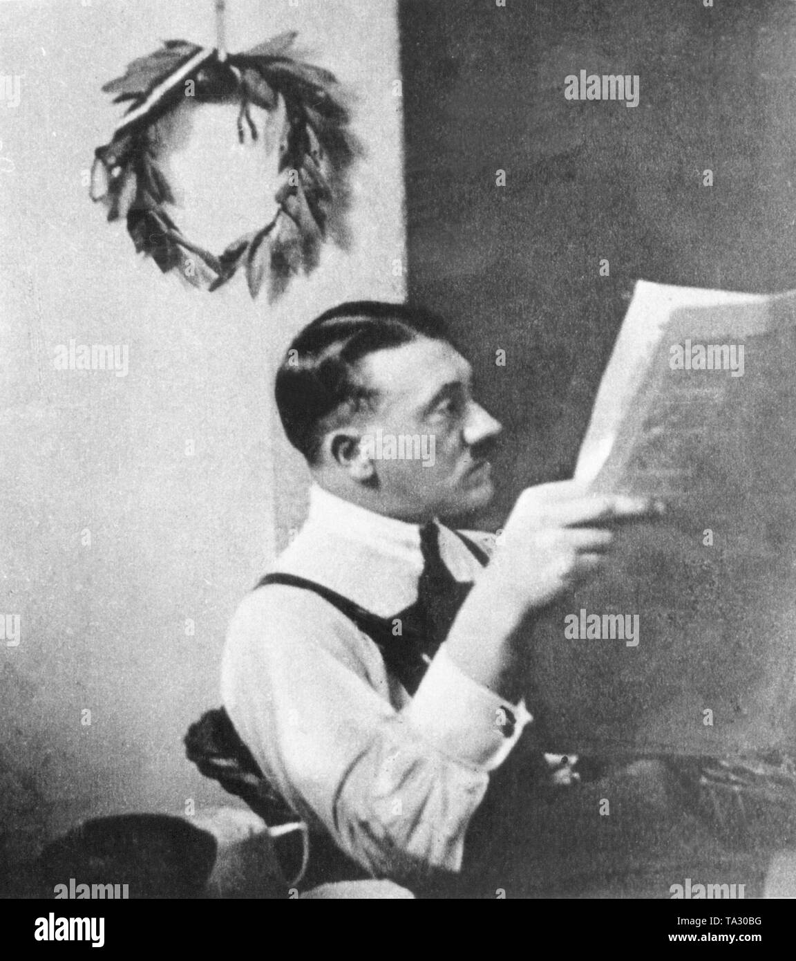 Adolf Hitler mit einem Lorbeerkranz der alten Gewinner, voller Symbolik, die an der Wand hängen in seiner Zelle im Gefängnis in Landsberg am Lech, wo er seine Strafe kurz nach dem gescheiterten Putschversuch am 9. November 1923 in München serviert. Stockfoto