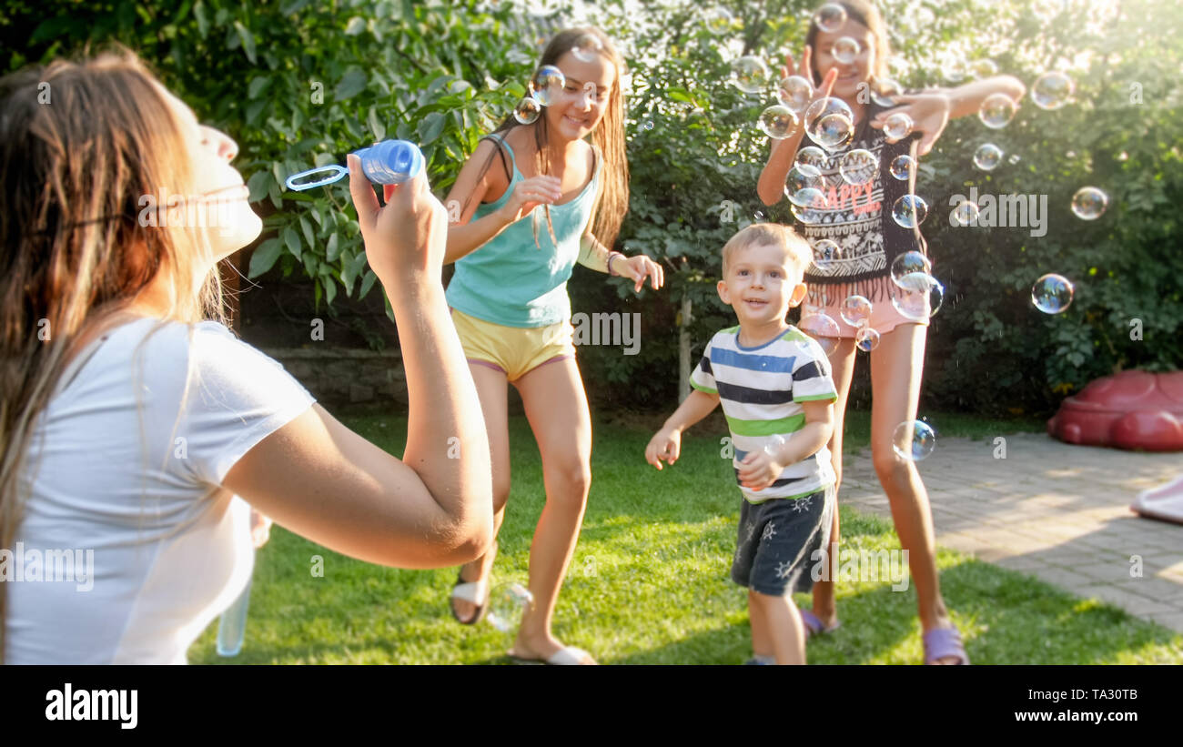 Foto von Happy Family spielen mit Seifenblasen im Haus Garten im Hinterhof. Familie Spiel und Spaß im Freien im Sommer Stockfoto