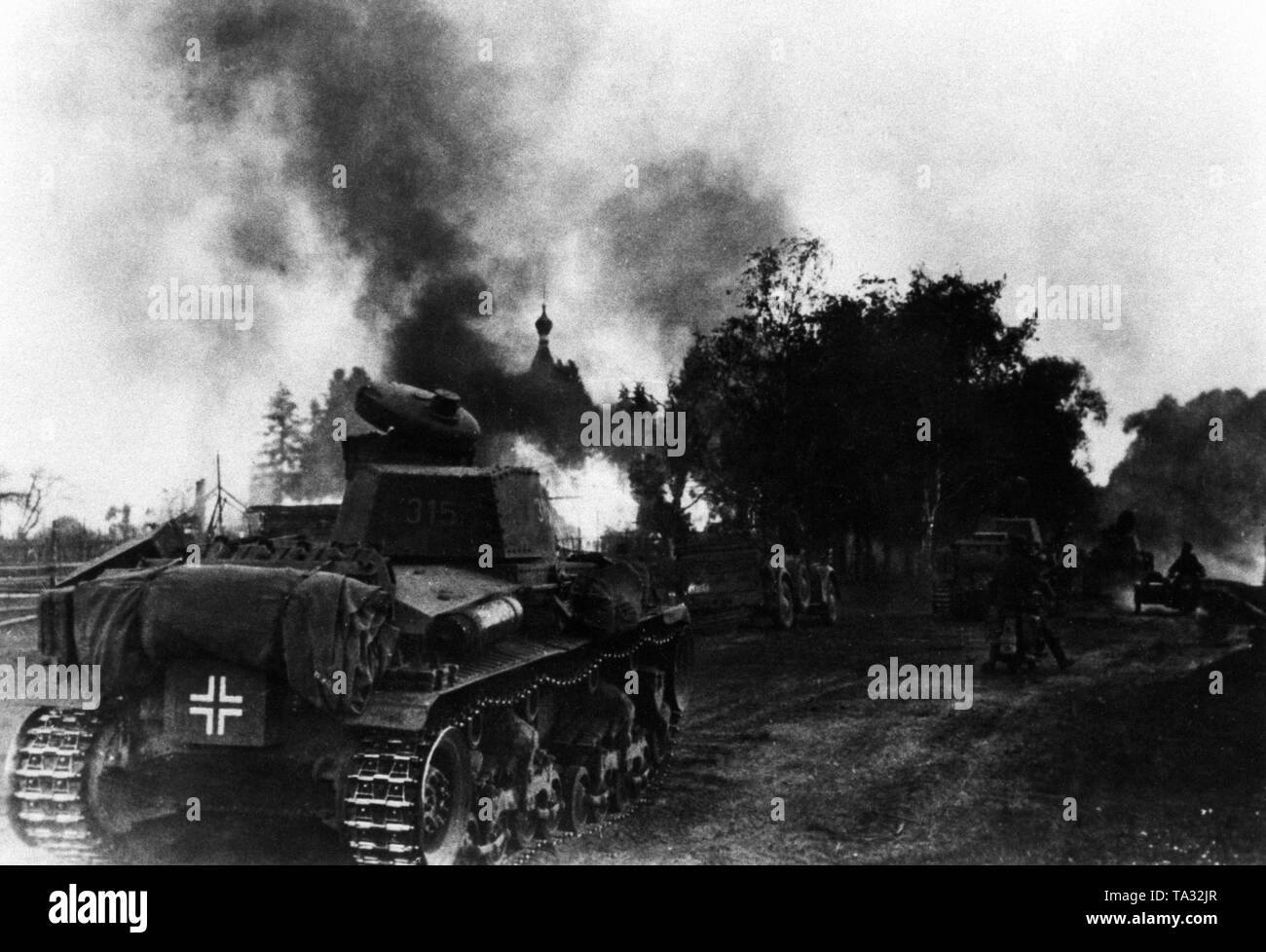 Panzer 35 (t) des 6. Panzerdivision auf dem Vormarsch durch ein brennendes Dorf an der Ostfront. Bereich Army Group North. Stockfoto