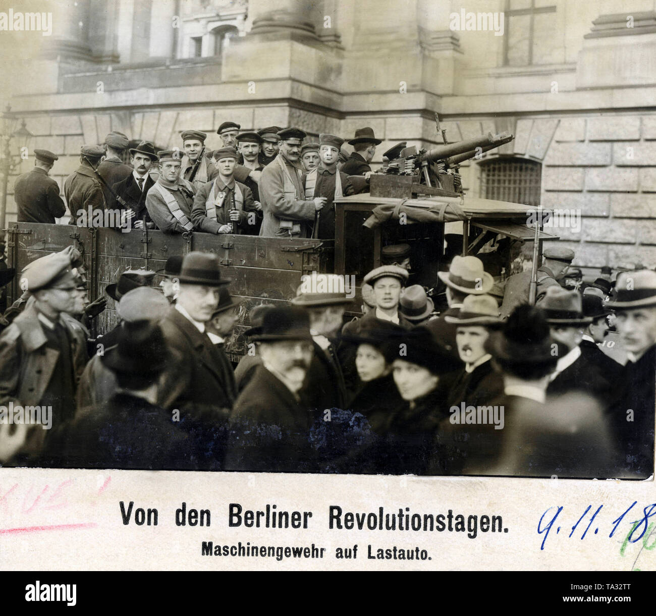 Bewaffnete revolutionäre Stehen auf einem komnick Lkw vor dem Berliner Schloss, dass von der Volksmarine Division besetzt wurde, der Arbeiter und Matrosen bewaffnet sind, unter anderem mit einem Maschinengewehr 08/15. Stockfoto