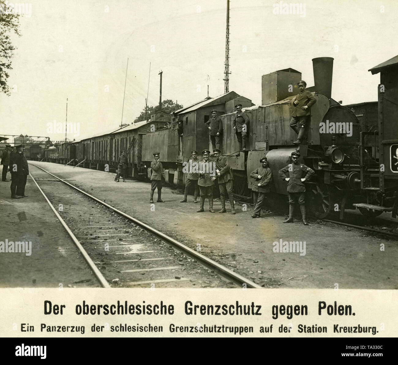 Soldaten der Grenztruppen, der Freikorps Mitglieder, posieren vor einem gepanzerten Zug am Bahnhof in Kreuzburg (kluczbork) während der ersten polnischen Aufstand in Oberschlesien. Stockfoto