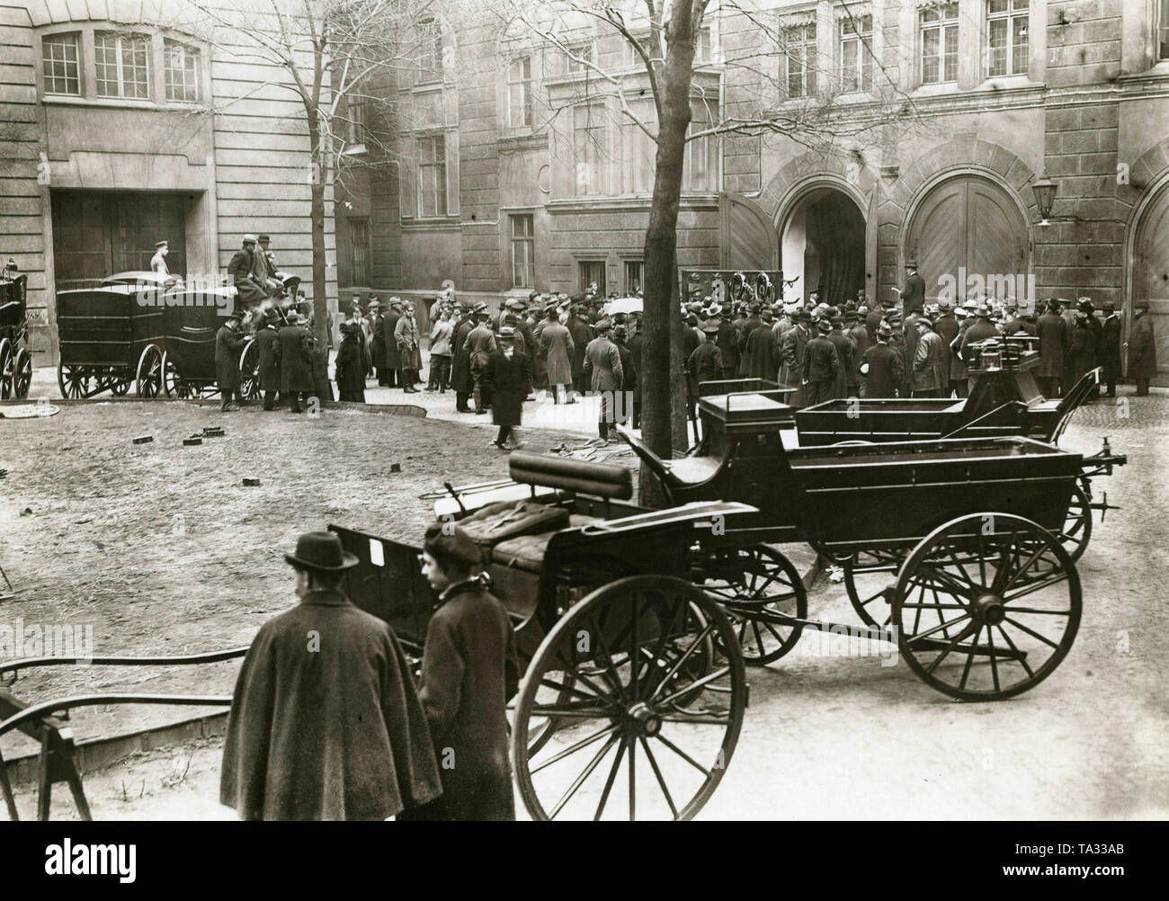 Wagen und Pferdegeschirr des kaiserlichen Eigentum versteigert vor der Berliner Marstall. Vor dem Tor in die Königlichen Stallungen (Marstall), eine Menge um dem Versteigerer gesammelt. Stockfoto
