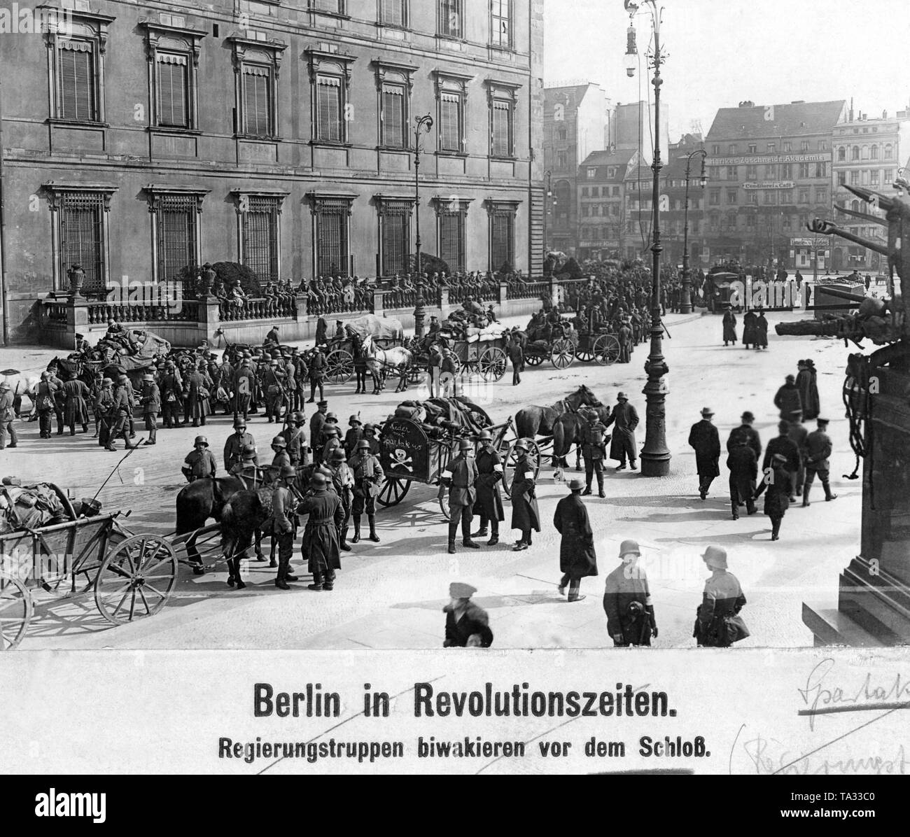 Im Zuge der Berliner Maerzkaempfe (März kämpft) im Jahr 1919 wurde von der Regierung loyalen Soldaten vor dem Berliner Stadtschloss gesammelt. Ein weißes Totenkopf und der Aufschrift "Nieder mit Spartakus" (Unten mit Spartacus) ist auf einem Wagen lackiert. Auf der rechten Seite ist ein Teil der nationalen Kaiser-Wilhelm-Denkmal. Stockfoto