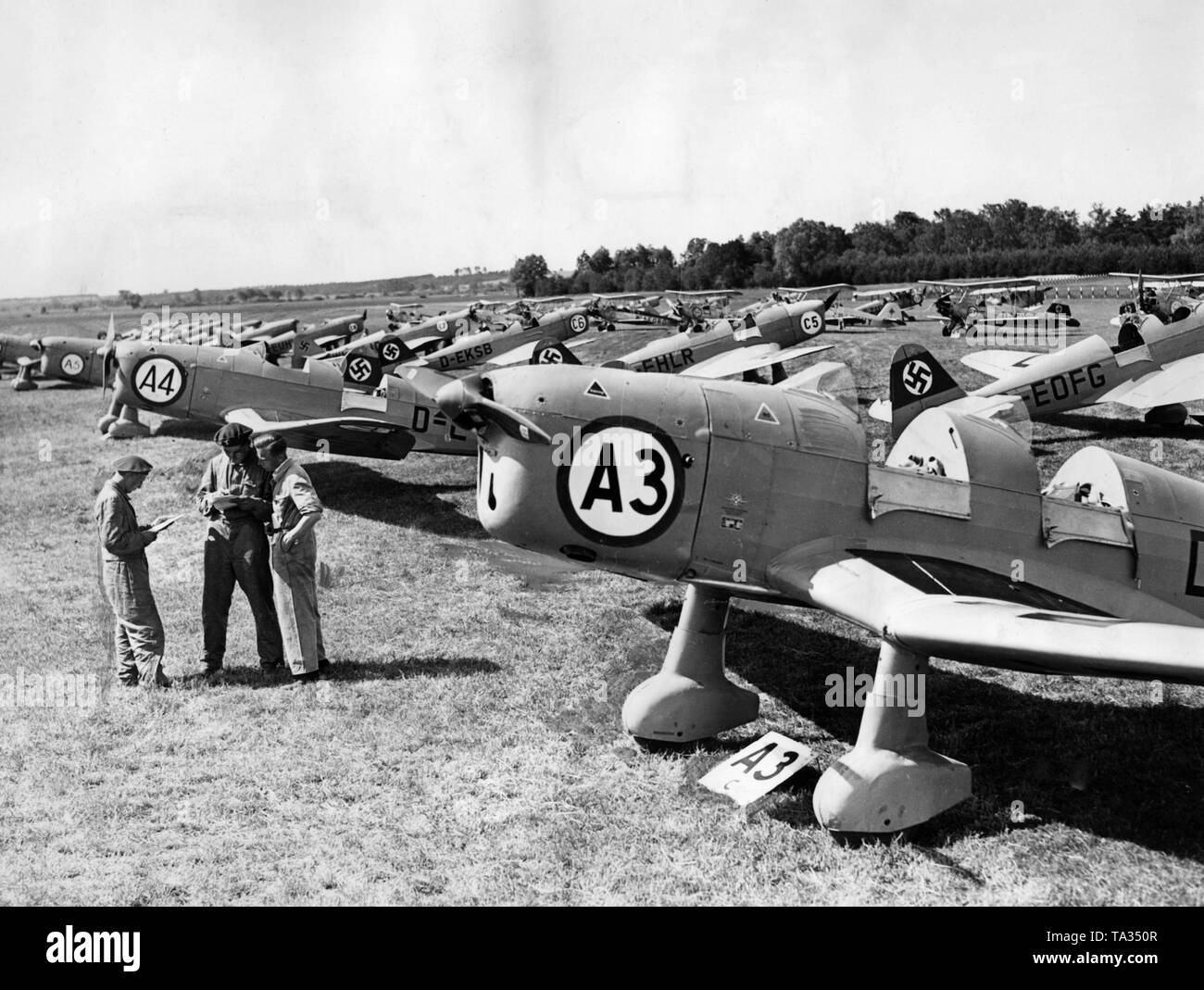 Eine Reihe von Flugzeugen und Männer haben am Flugplatz Rangsdorf für einen Nord-ost-deutschen Tour der Nationalsozialistischen Air Corps gesammelt. Stockfoto