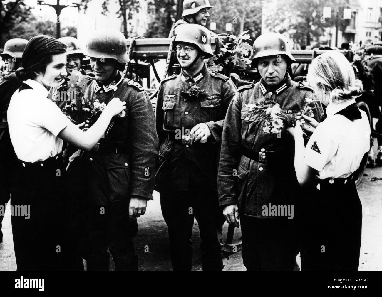 BDM-Mädchen willkommen Die zurückkehrenden Soldaten aus den westlichen Kampagne in Frankreich mit Blumen auf der Ost-West-Achse während der siegesparade. Stockfoto