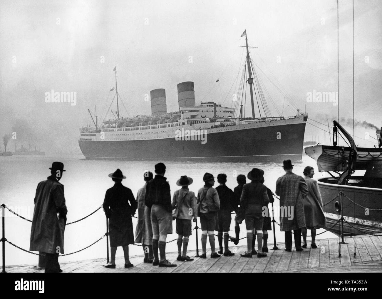 Der Ocean Liner 'Mauretania' erreicht den Hafen von London nach ihrer ersten Reise nach New York über die Themse. Die 'Mauretania' war das größte Schiff, das jemals die Themse gesegelt. Stockfoto