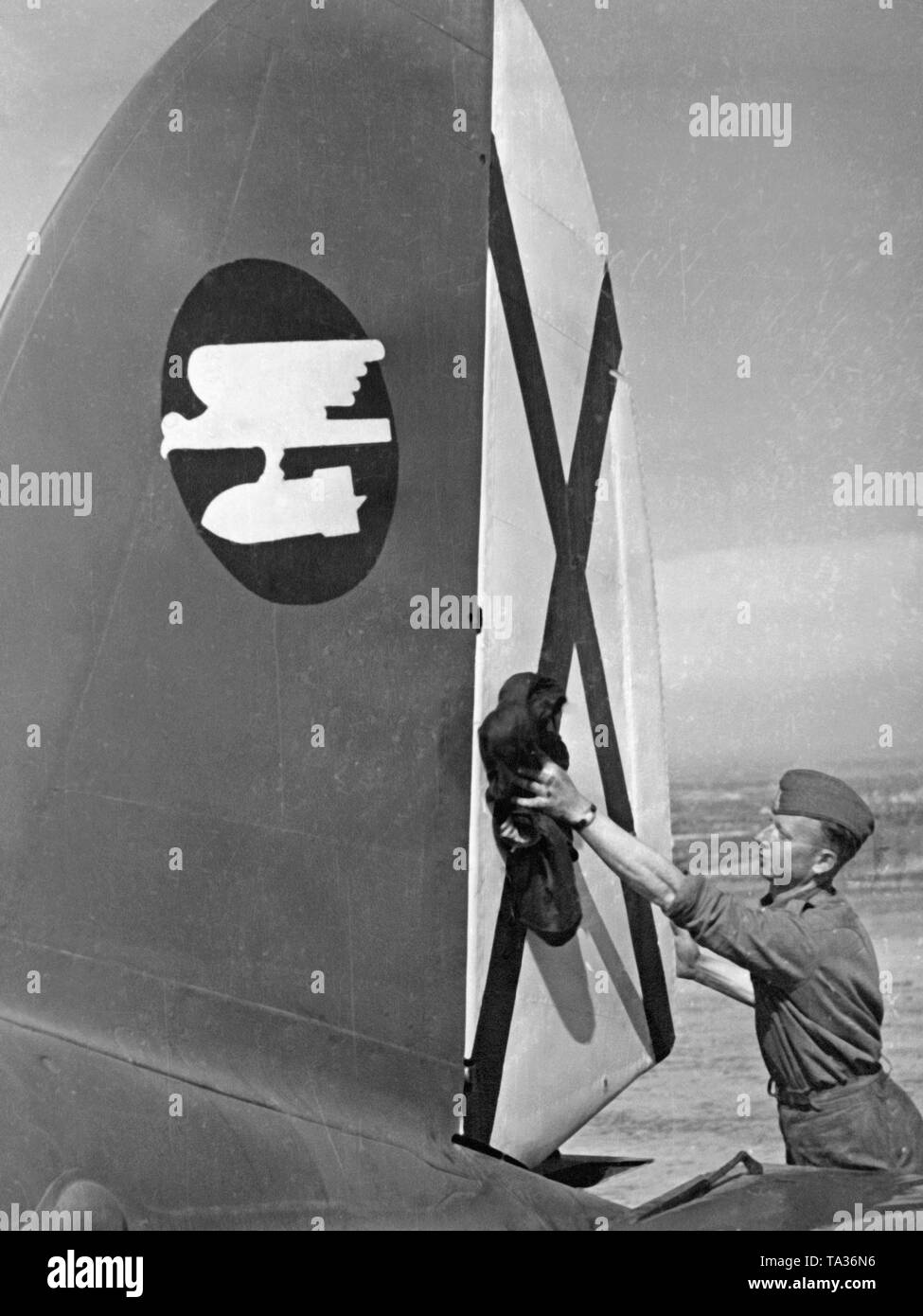 Foto von einem Legionär aus dem Boden Personal der Fliegertruppe (Luftwaffe) der Legion Condor, die Reinigung ist ein seitenleitwerk der Jagdbomber Heinkel He 111 auf einem Flugplatz in Spanien, 1939. Das Flugzeug gehört zu den Battle Group 88. (Hull Kokarde: eagle Durchführung Sturzflug mit Bombe). Auf dem Display der Saint Andrew's Cross, der Schwanz Kokarde der spanischen Luftwaffe. Stockfoto