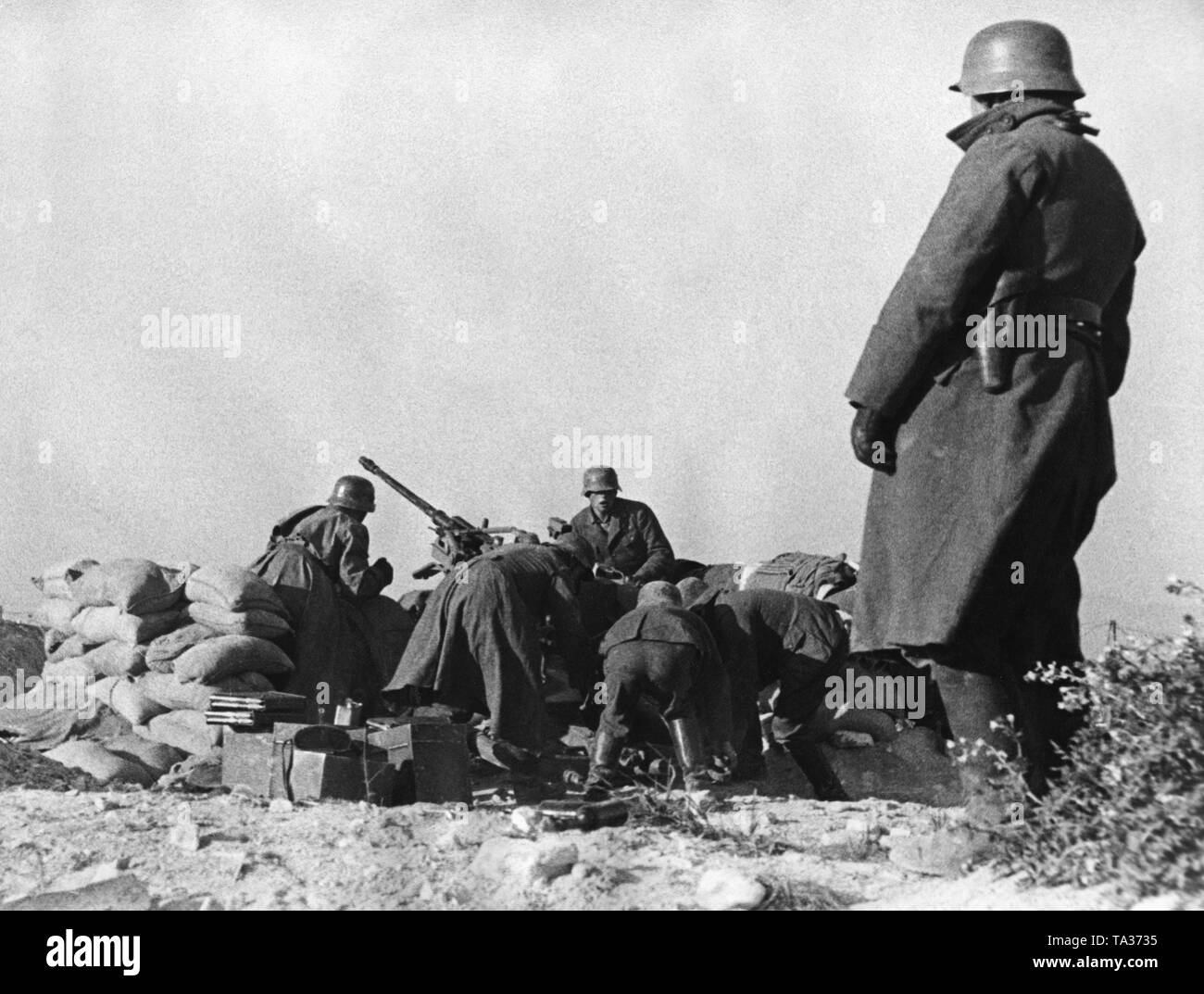 Undatiertes Foto von einer anti-Flugzeuge der Legion Condor in einem Boden Angriff. Die Soldaten mit einer 2-cm-Flak 30 für den Betrieb. Die Position wird durch Sandsäcke geschützt. Im Vordergrund stehenden Offizier. Die Soldaten tragen M 35 Stahlhelme. Stockfoto