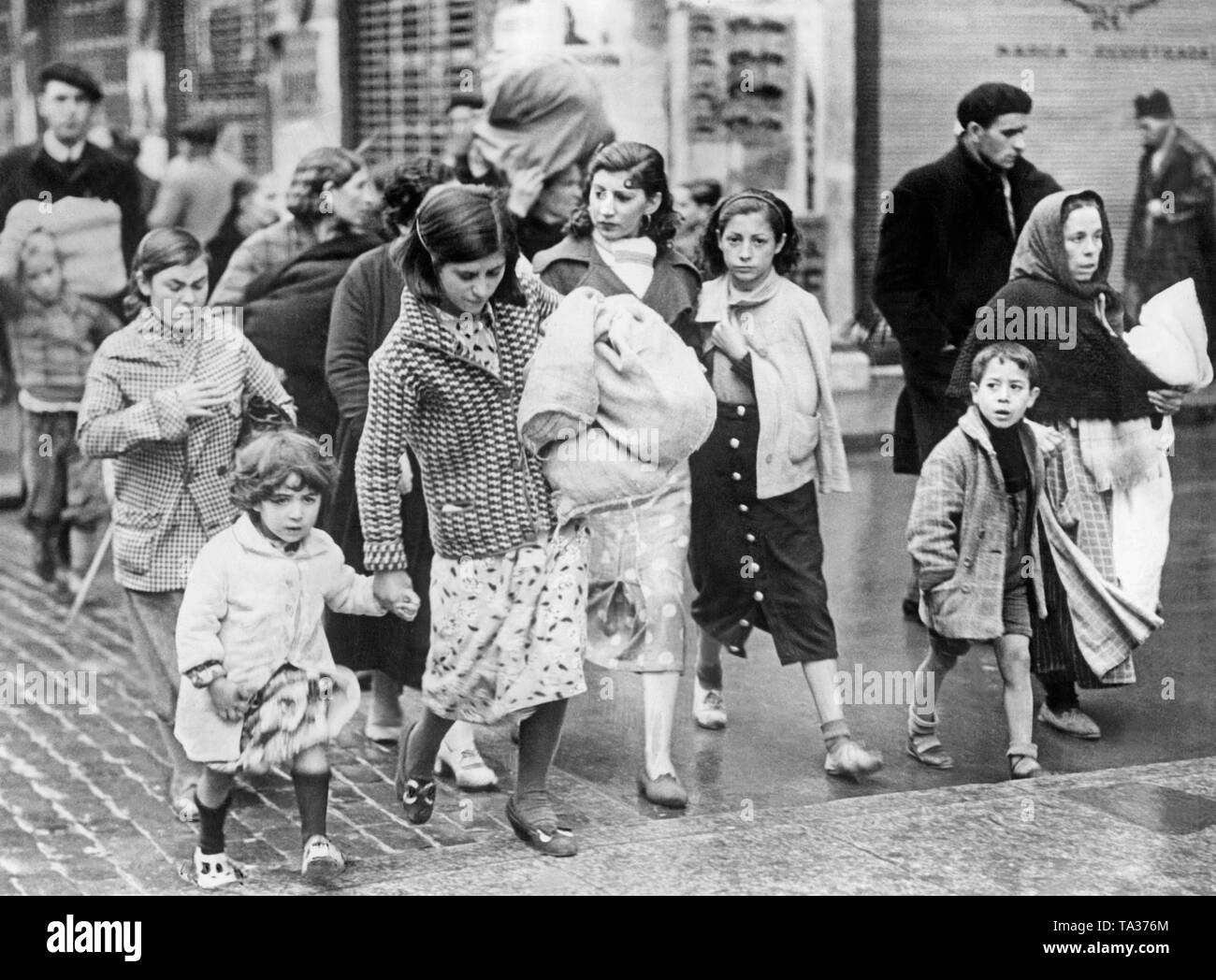 Foto von einer Gruppe von Frauen und Kindern, die auf der Flucht von Madrid nach dem Ausbruch der Kämpfe in der spanischen Hauptstadt im Sommer 1936. Stockfoto