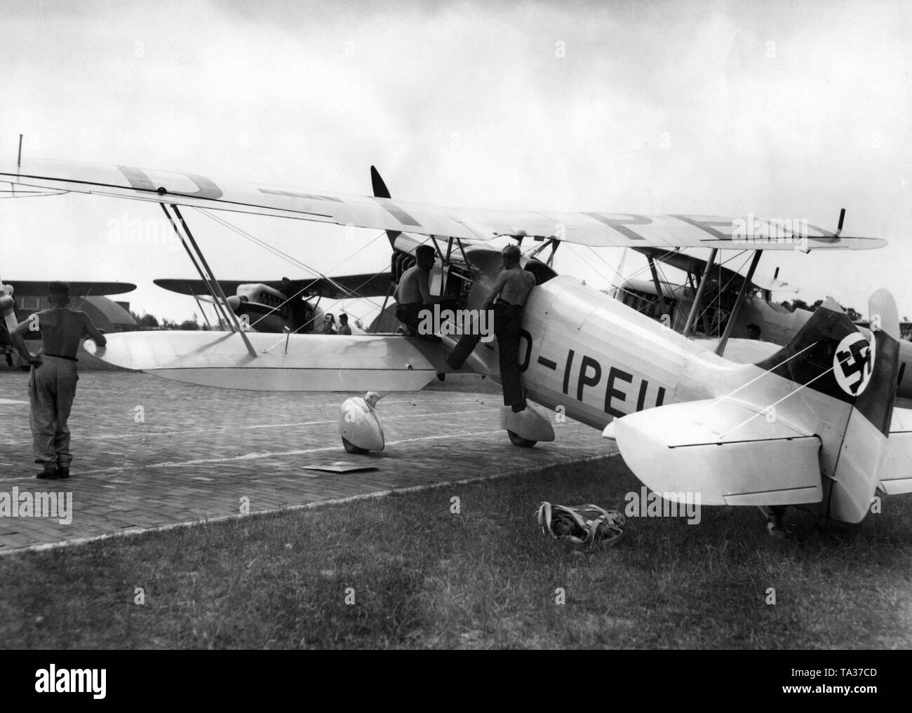 Ein geschwader an der Tankstelle vor Beginn einer Ausbildung Flug, ihre Flugzeuge sind Heinkel He 51. Die Er51 war zwischen 1934 und 1937 produziert, ab 1936 wurde zum Teil von der Arado Ar 68 ersetzt und ab 1937 intensiv von der Messerschmitt Bf 109 als Standard Kampfflugzeuge ersetzt. Das Bild ist aus der Serie: "Ein Tag am Jagdgeschwader Richthofen'. Zu dieser Zeit ist das fliegergeschwader Doeberitz erhielt die Auszeichnung 'Richthofen', erhielt aber der endgültige Name JG 2 "richthofen" nur auf 1.5.1939, unter dem er später im Zweiten Weltkrieg beteiligt. Stockfoto