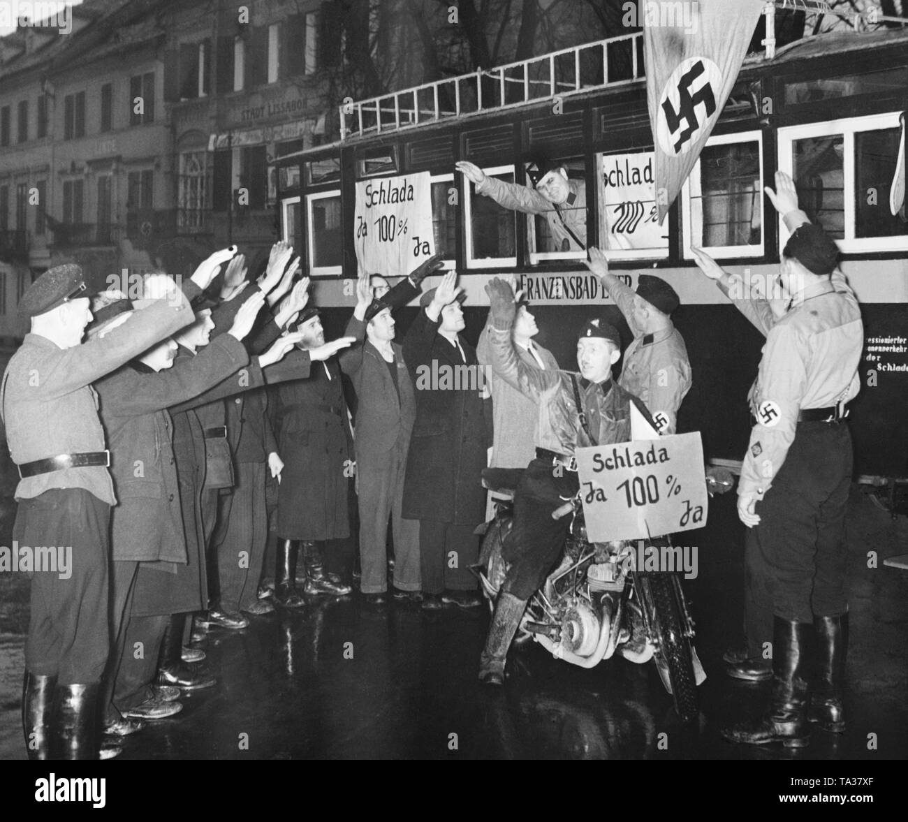 Storm Trooper (Mitglied der SA) in Eger im Sudetenland. Die Männer sind, die sich für das Sudetendeutsche Nachwahlen. Bei den Wahlen, abgegebenen Stimmen über die Annexion des Sudetenlandes an das Deutsche Reich. Auf der Schilder und Poster: chlada (Slatina) JA 100% Ja'. Die umliegenden Sudetendeutschen die Storm troopers mit dem Hitlergruss begrüßen. Stockfoto