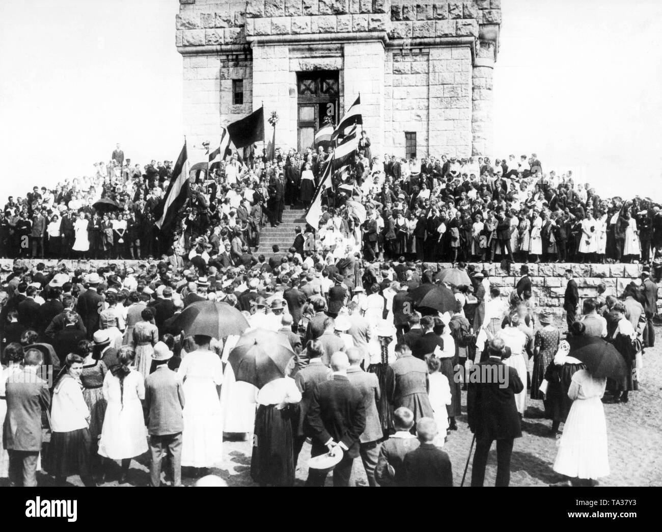 Im Sommer 1921 Jugendgruppen aus den gefährdeten Gebieten im Osten am Fuß der Bismarckwarte auf der Mueggelberg in der Nähe von Berlin versammelt, um gegen die Abtretung an Polen zu demonstrieren. Gustav Stresemann spricht zu den Teilnehmern durch die kaiserlichen Flagge gerahmt. Stockfoto