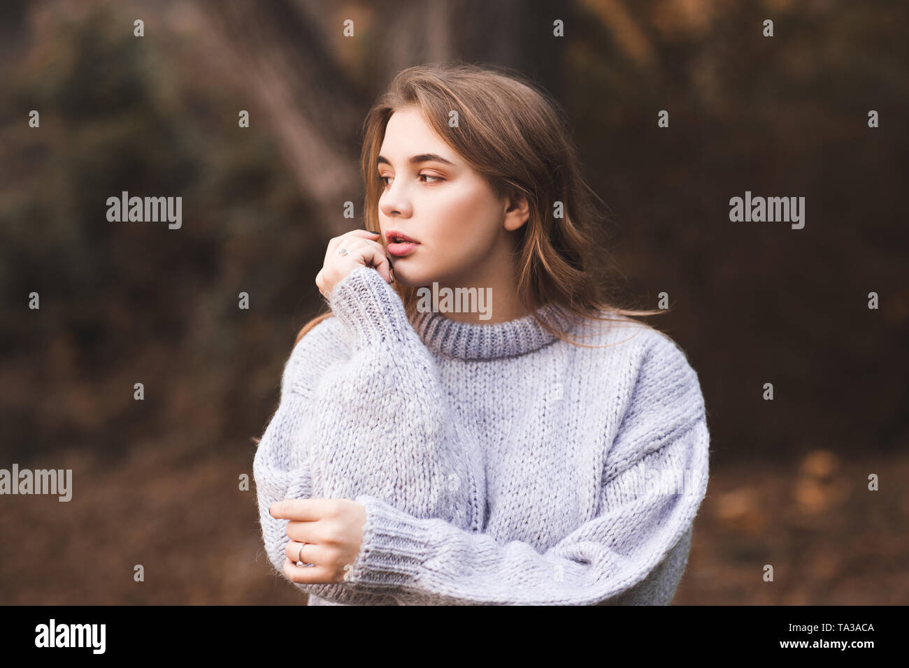 Stilvoll jugendlich Mädchen mit gemütlichen Pullover gestrickt posiert im Freien. Herbst Saison. 20. Stockfoto