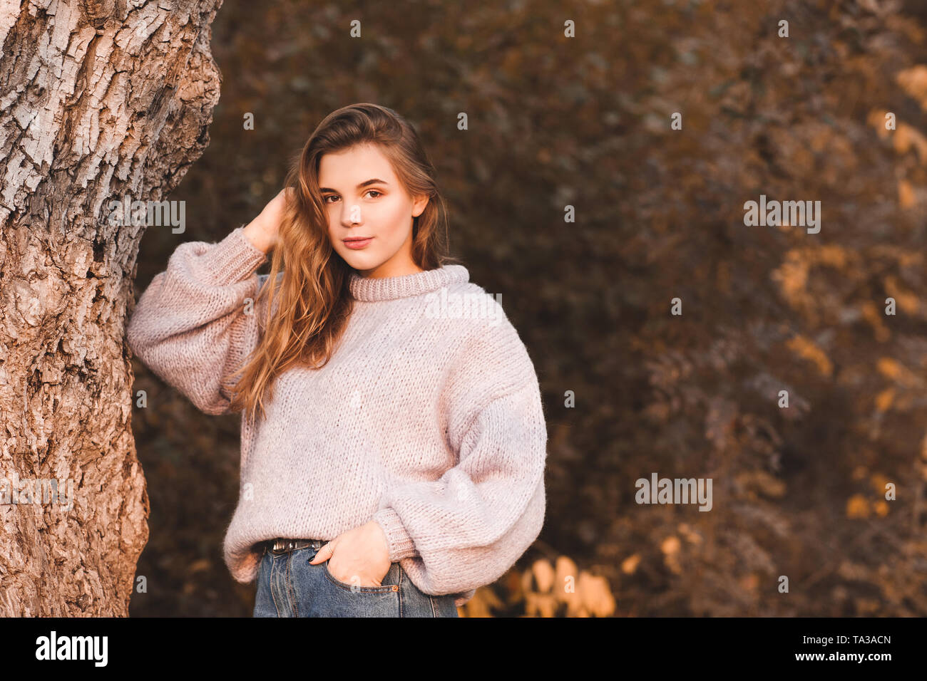 Smiling teenage Mädchen 17-18 Jahre alten tragen Strickpullover posiert im Freien. Mit Blick auf die Kamera. Herbst Saison. 20. Stockfoto