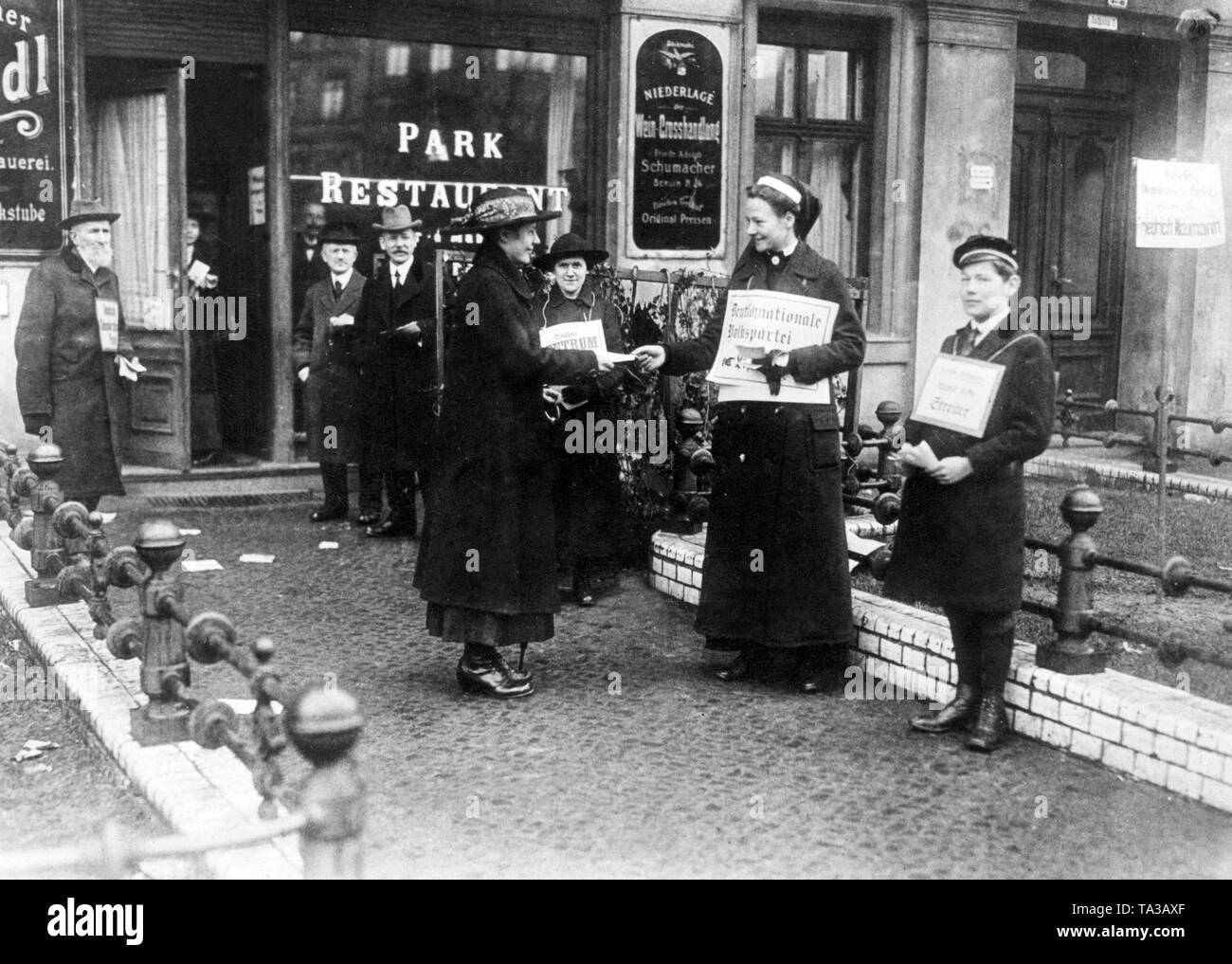 Rotkreuzschwester übergibt eine Propaganda Flyer ein Wähler, wie eine Wahl Arbeiter der Deutschnationalen Volkspartei. Zum ersten Mal in der deutschen Geschichte, Frauen durften an den Wahlen der Nationalversammlung als gleichberechtigte Bürger zu nehmen, da sie das aktive und passive Wahlrecht erhalten hatte. Stockfoto