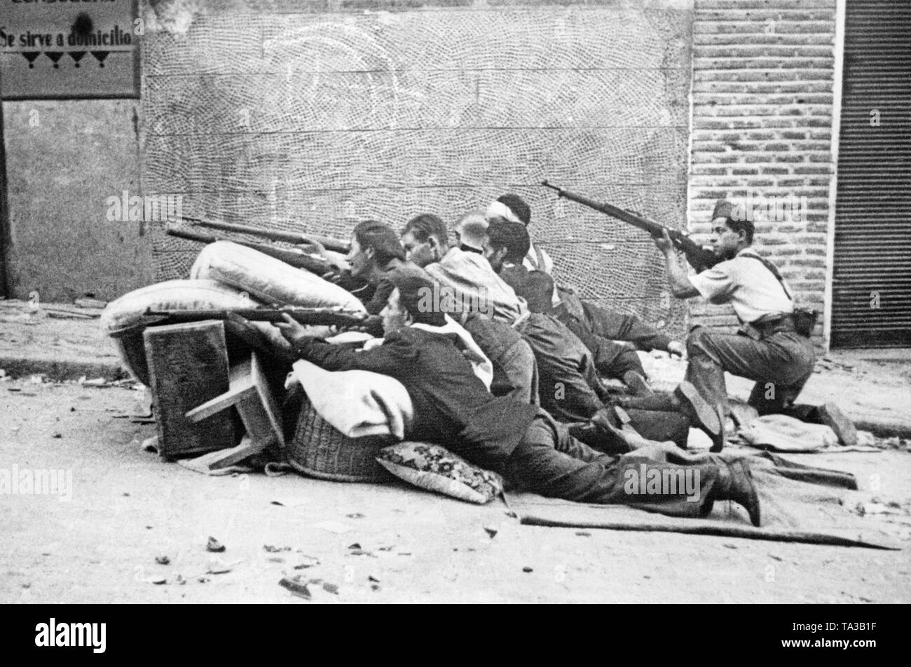 Foto von republikanischen Soldaten mit Gewehren versteckt hinter einer Barrikade in den Straßen von Toledo während der Belagerung von den Alcazar von Toledo im Sommer 1936. Stockfoto