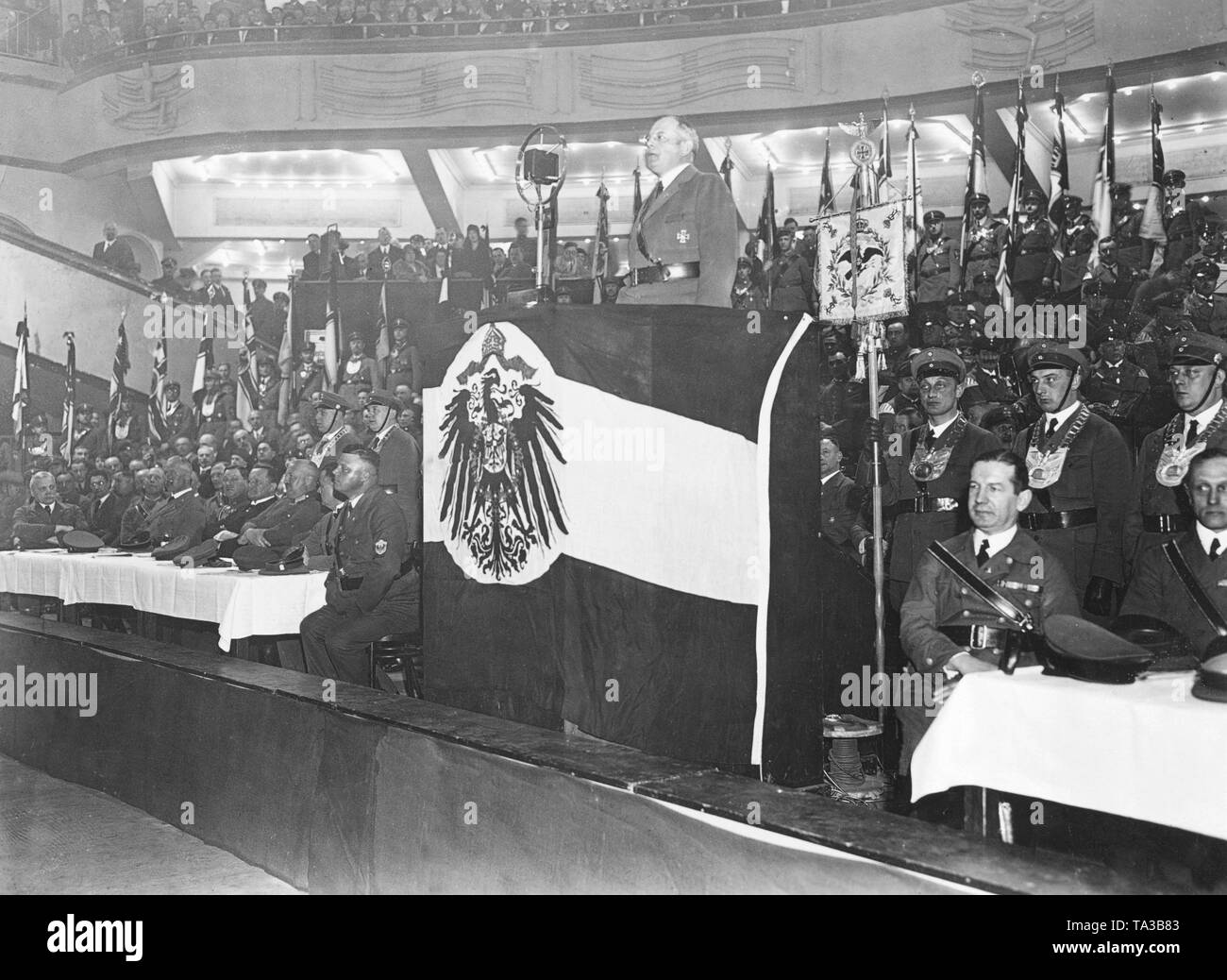 Der Führer der Stahlhelm, Franz Seldte, hält eine Rede im Zuge einer Demonstration für das Referendum der Stahlhelm mit der Nachfrage der Preußischen Diät aufzulösen. Das Podium ist mit der Flagge des Reiches eingerahmt. Stockfoto