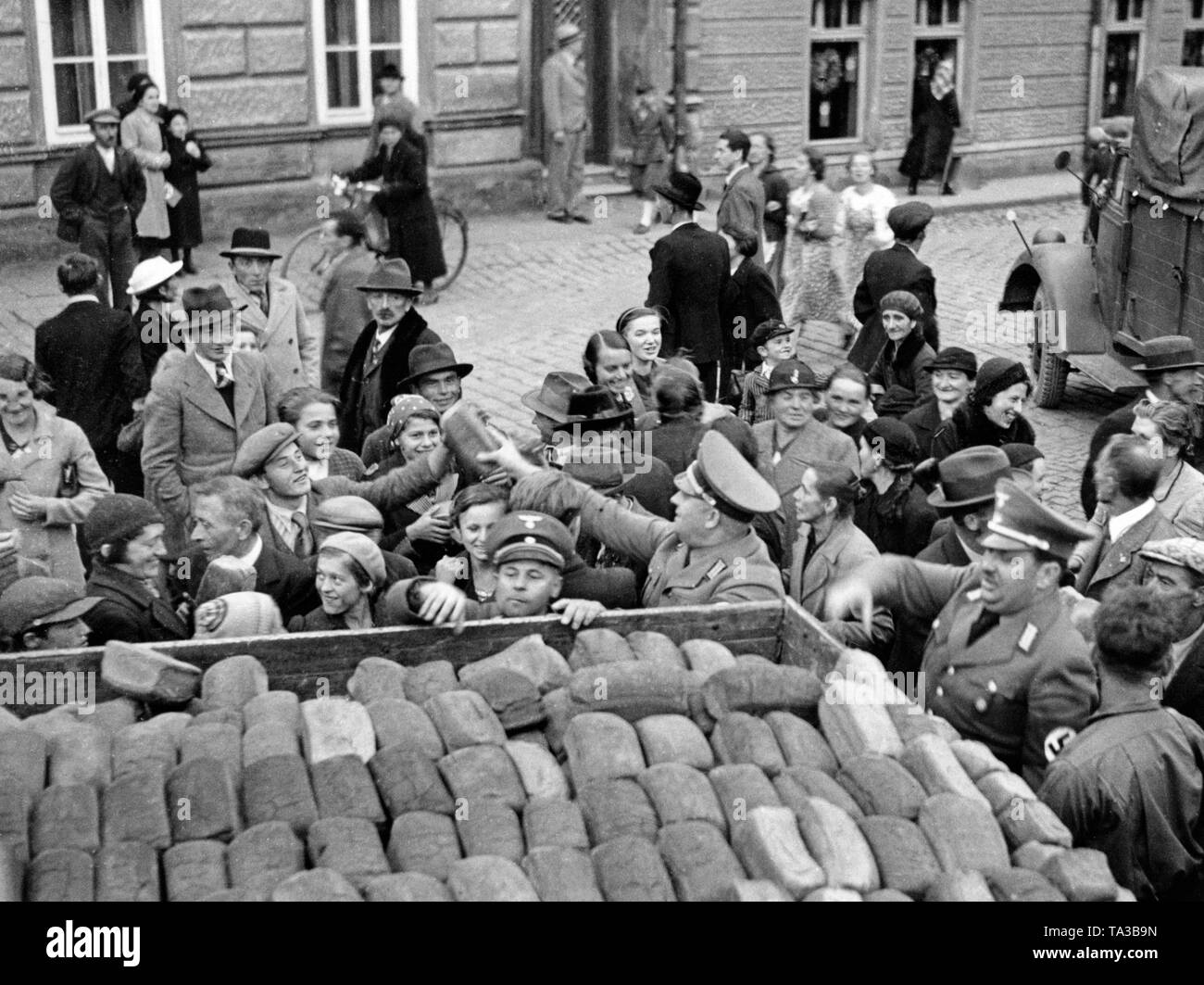 Uniformierte NSDAP-Mitglieder einen Brötchenservice an die Bevölkerung verteilen in Freudenthal (heute Bruntal) am 7. Oktober 1938, im Rahmen eines Programms der Winterhilfswerk (Whw) nach der Besetzung des Sudetenlandes. Stockfoto
