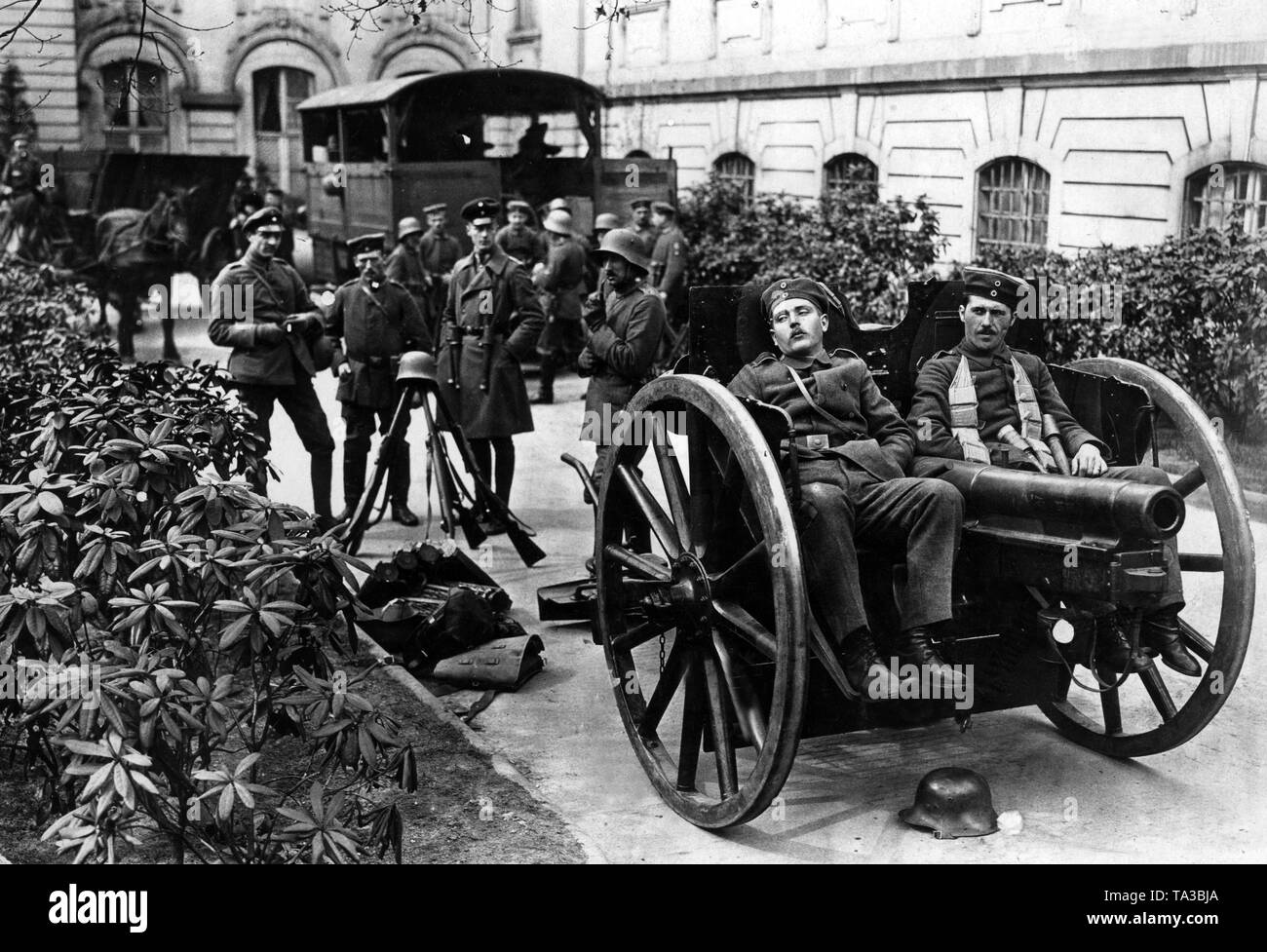 Regierung Loyalisten machen Sie eine Pause nach ihrer Ankunft in der Reichskanzlei. Im Vordergrund zwei Soldaten ruht auf einem 7,7 cm Feldkanone 96 sind. Stockfoto