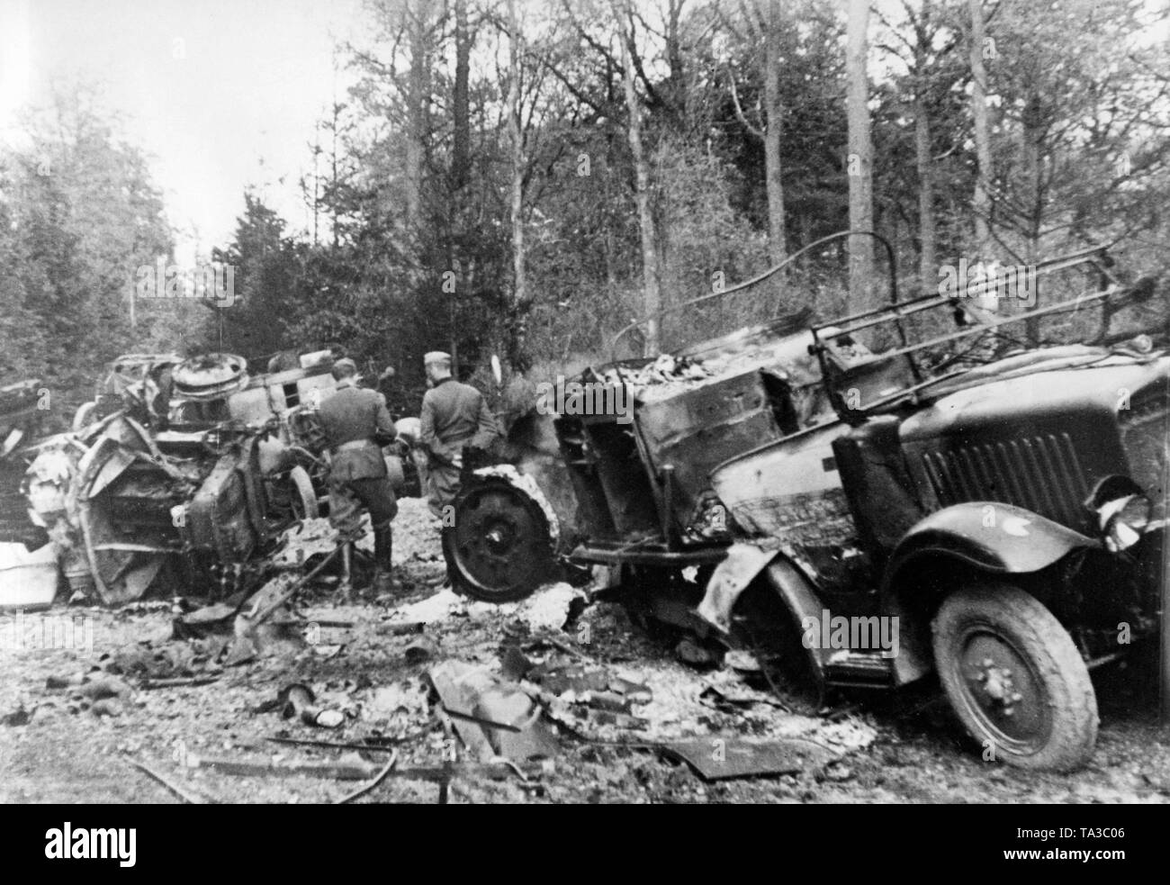 Wehrmachtssoldaten prüfen eine französische Versorgung Konvoi zerstört durch die Bomben der Luftwaffe. Stockfoto
